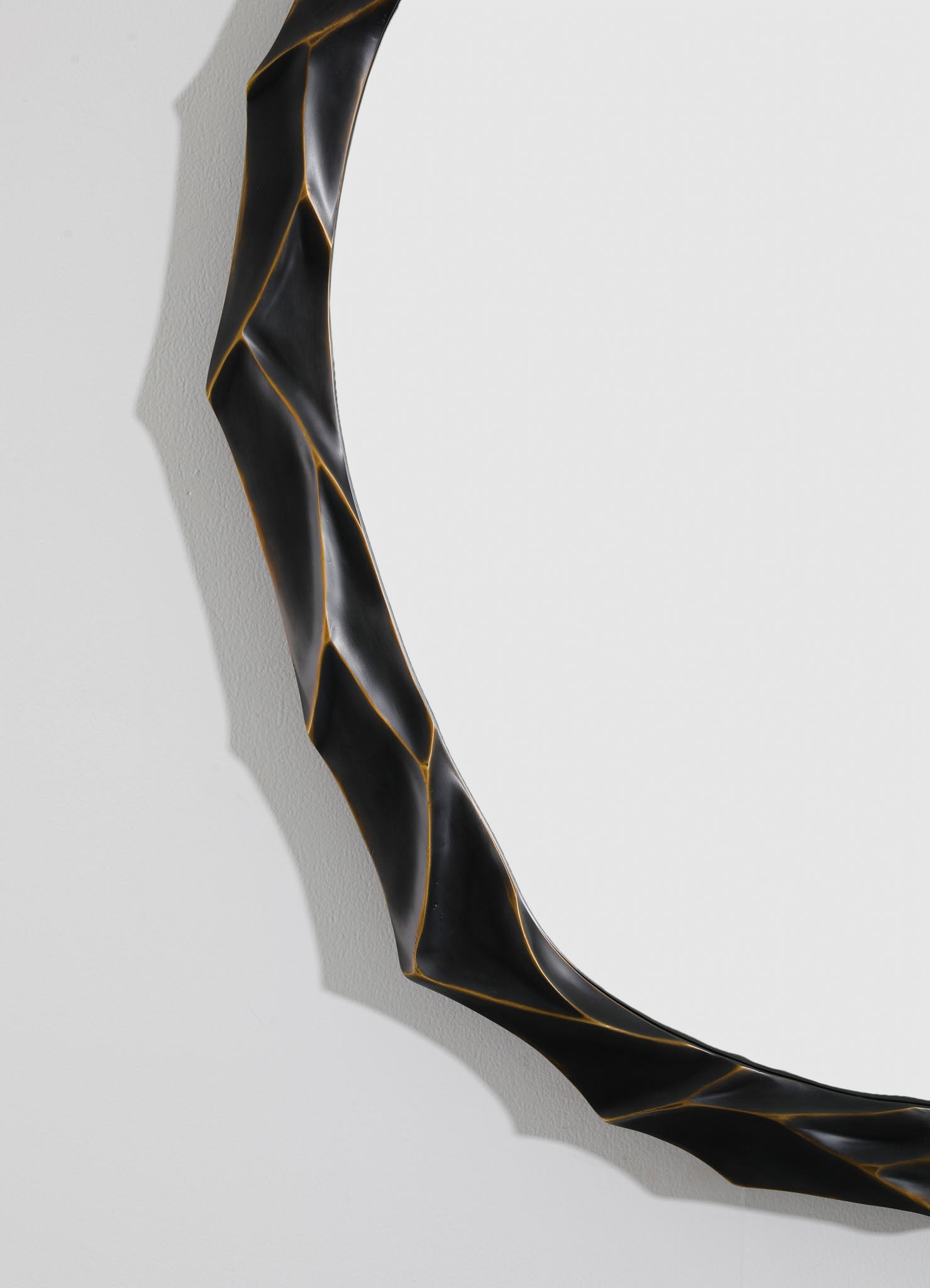 A black, twisted decorative object with gold accents, featuring a sleek, modern design and curved, sculptural form.