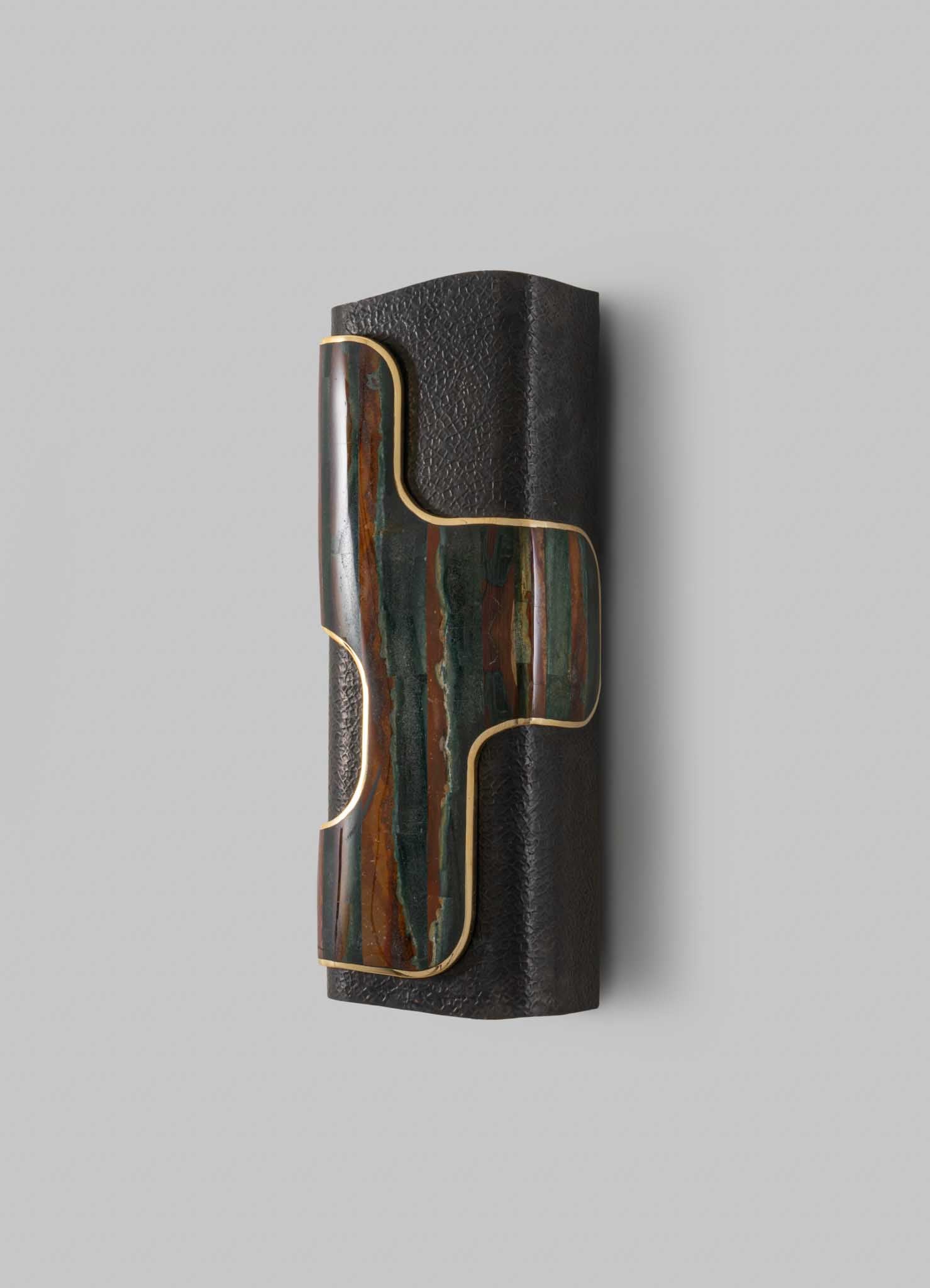 A decorative wall sconce featuring a rectangular black textured material with a colorful, abstract marble inlay outlined in gold, set against a plain light gray background.