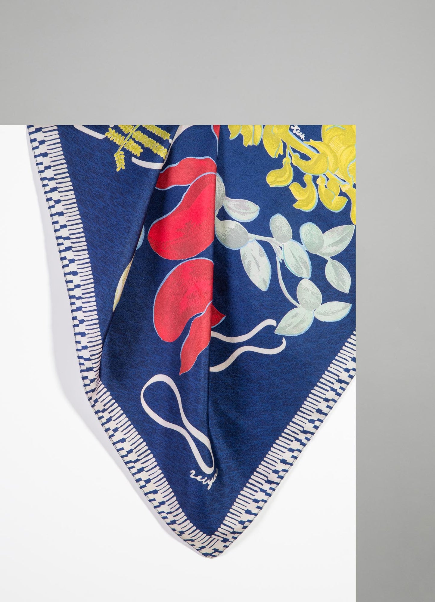 A fabric piece featuring a vibrant floral pattern on a deep blue background, with yellow, red, and white botanical motifs and a striped border in matching colors. The material appears to be lightweight and printed with bold, colorful design elements.