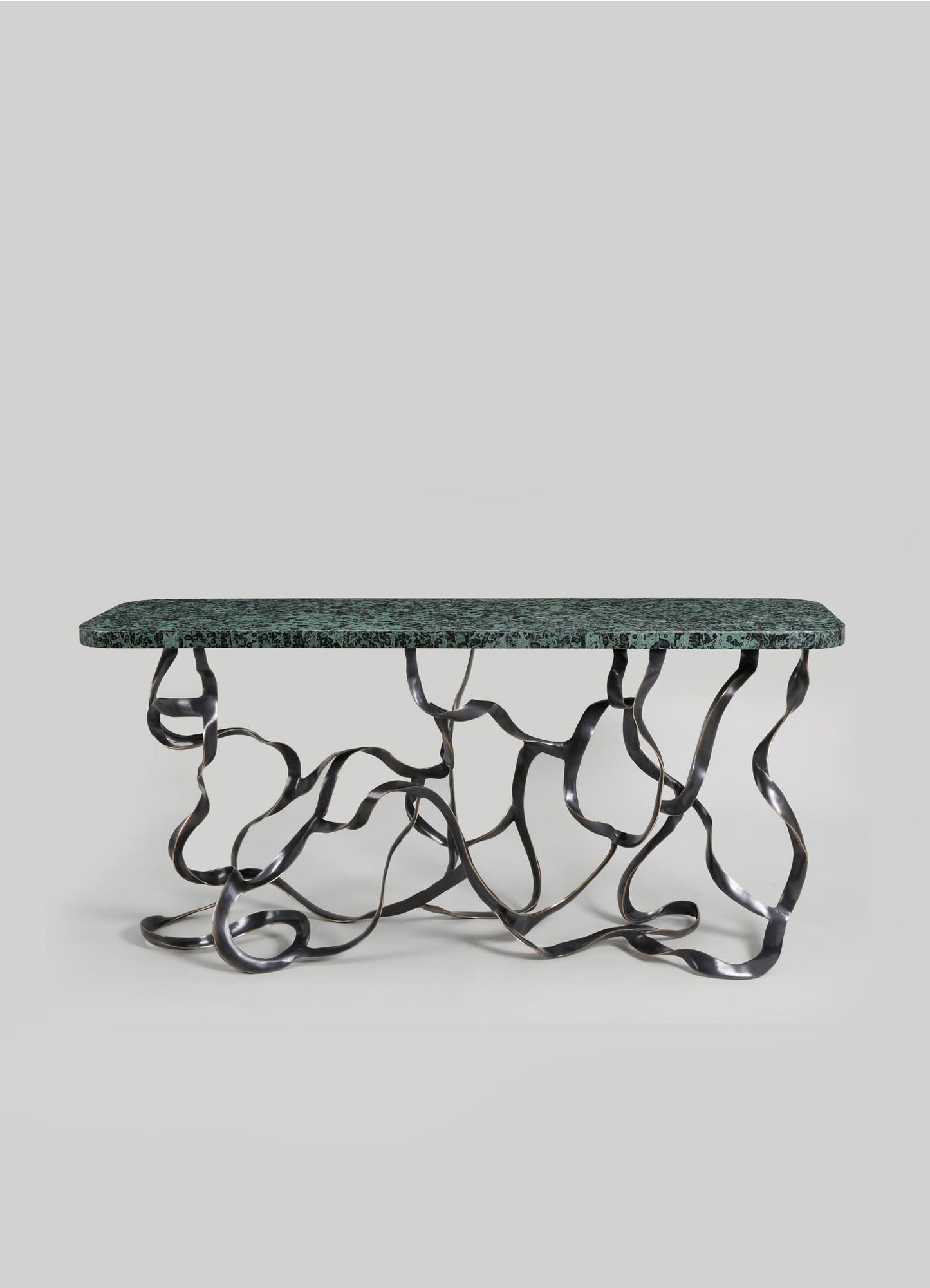 A contemporary console table with a rectangular green marble top and an intricate black metal base composed of twisting, organic-shaped legs.