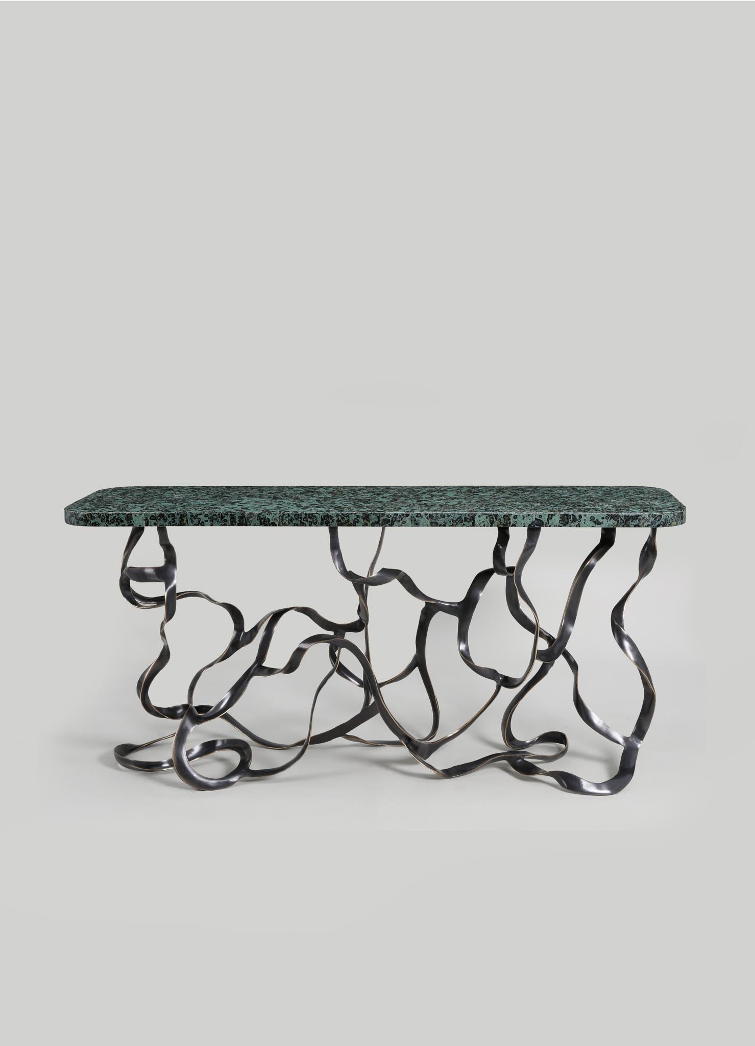 A contemporary console table with a rectangular green marble top and an intricate black metal base composed of twisting, organic-shaped legs.