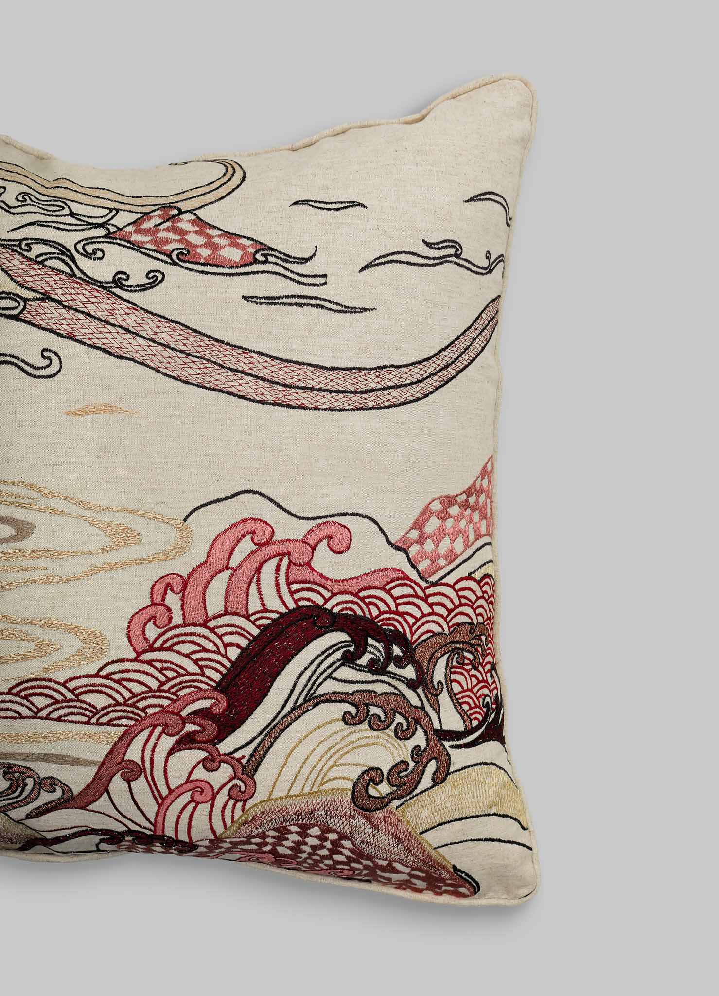The Viya Dreamscape Red Embroidered Cushion Cover B (24"x24") is shown partly on a gray background, displaying swirling red, pink, cream, and black embroidery with stylized wave motifs inspired by textile art.