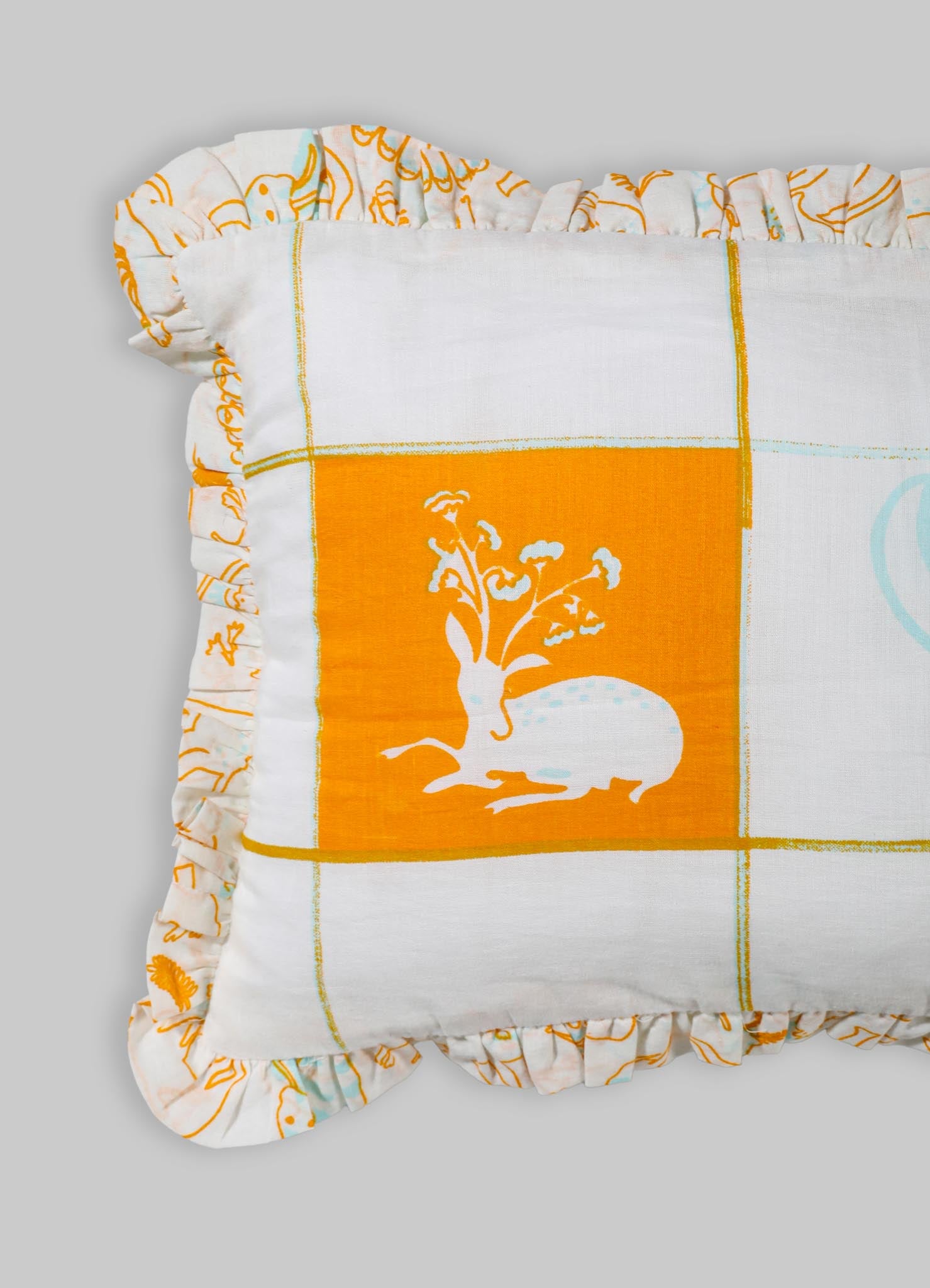 A decorative cushion cover made of cotton fabric with an orange and white color palette, featuring a floral motif and a ruffled edge. The design includes a grid pattern with a central floral illustration on a solid orange background.