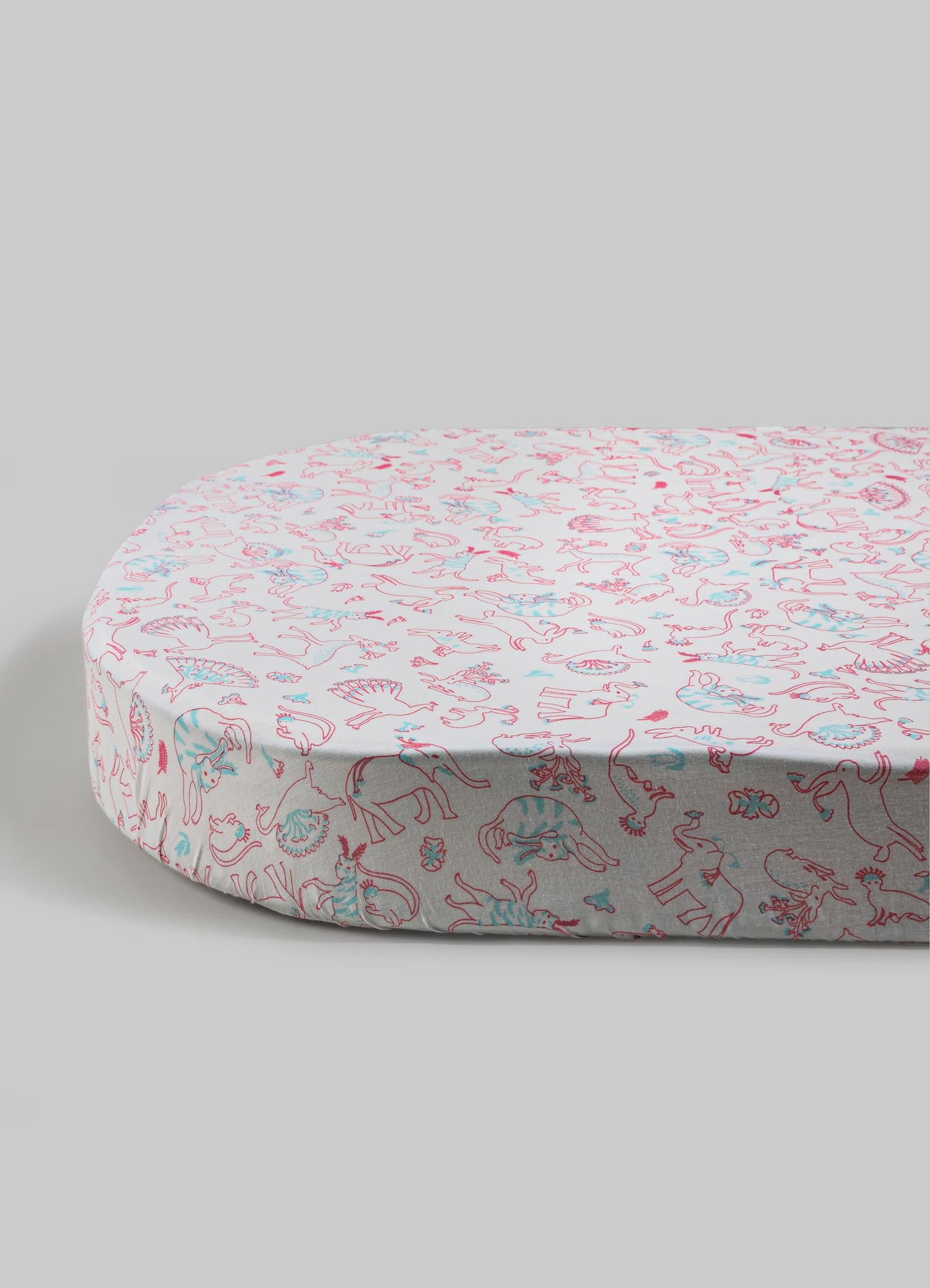Round mattress with a soft fabric cover featuring a colorful animal print pattern in pink and blue tones, set against a plain background.