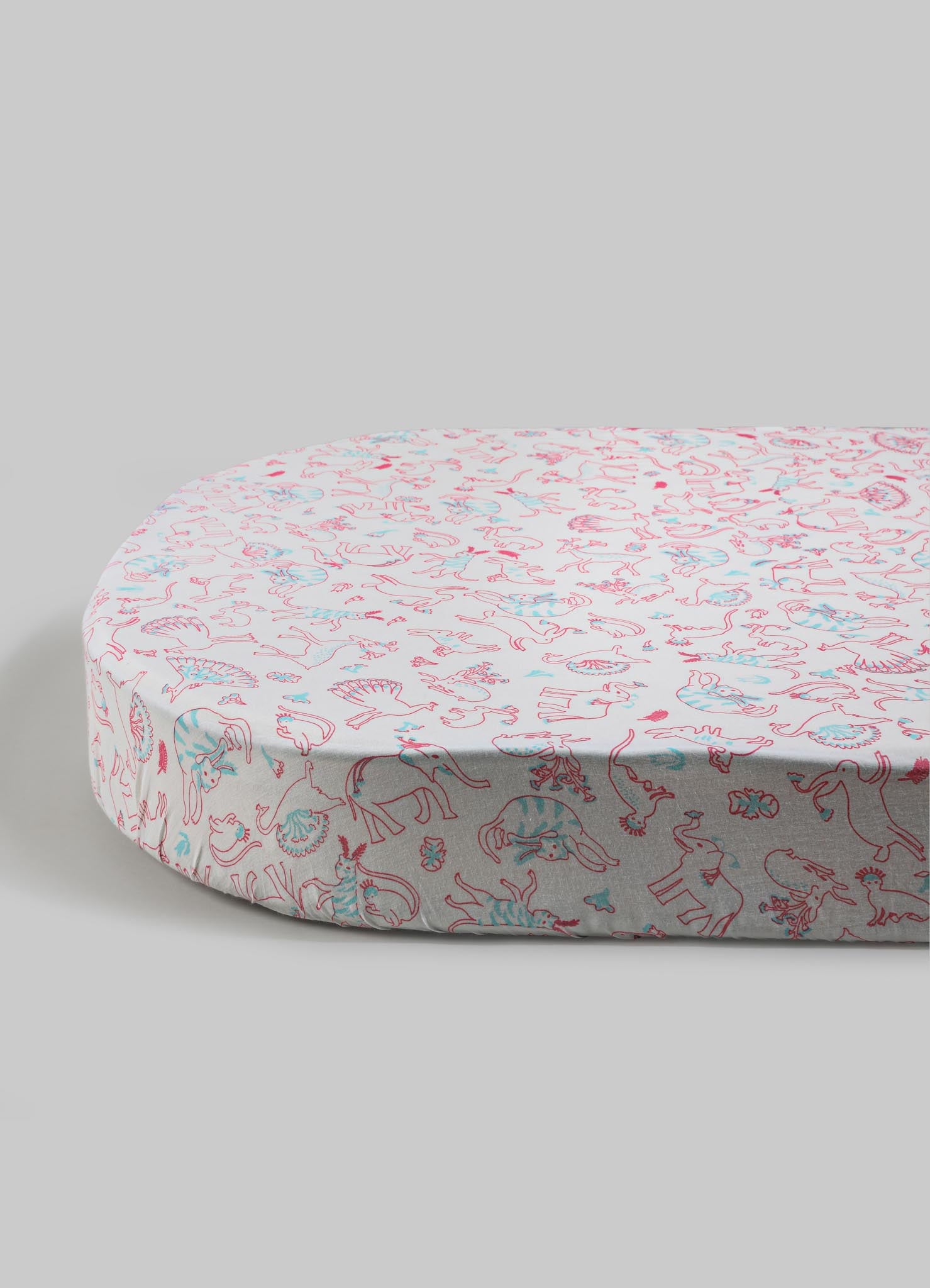 Round mattress with a soft fabric cover featuring a colorful animal print pattern in pink and blue tones, set against a plain background.