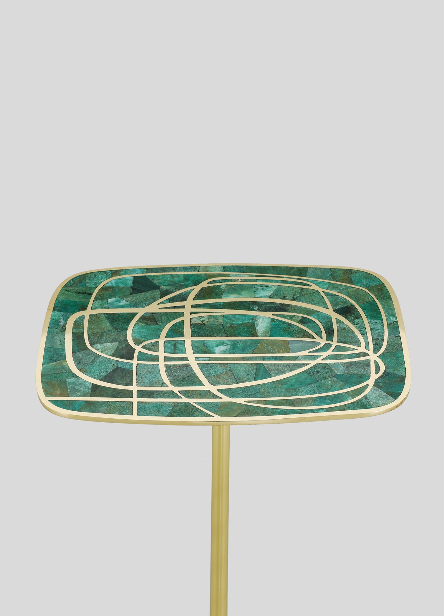 A side table with a square top featuring a mosaic pattern of green and blue stone fragments, outlined with gold metal lines creating an abstract geometric motif, supported by a slim gold stand.