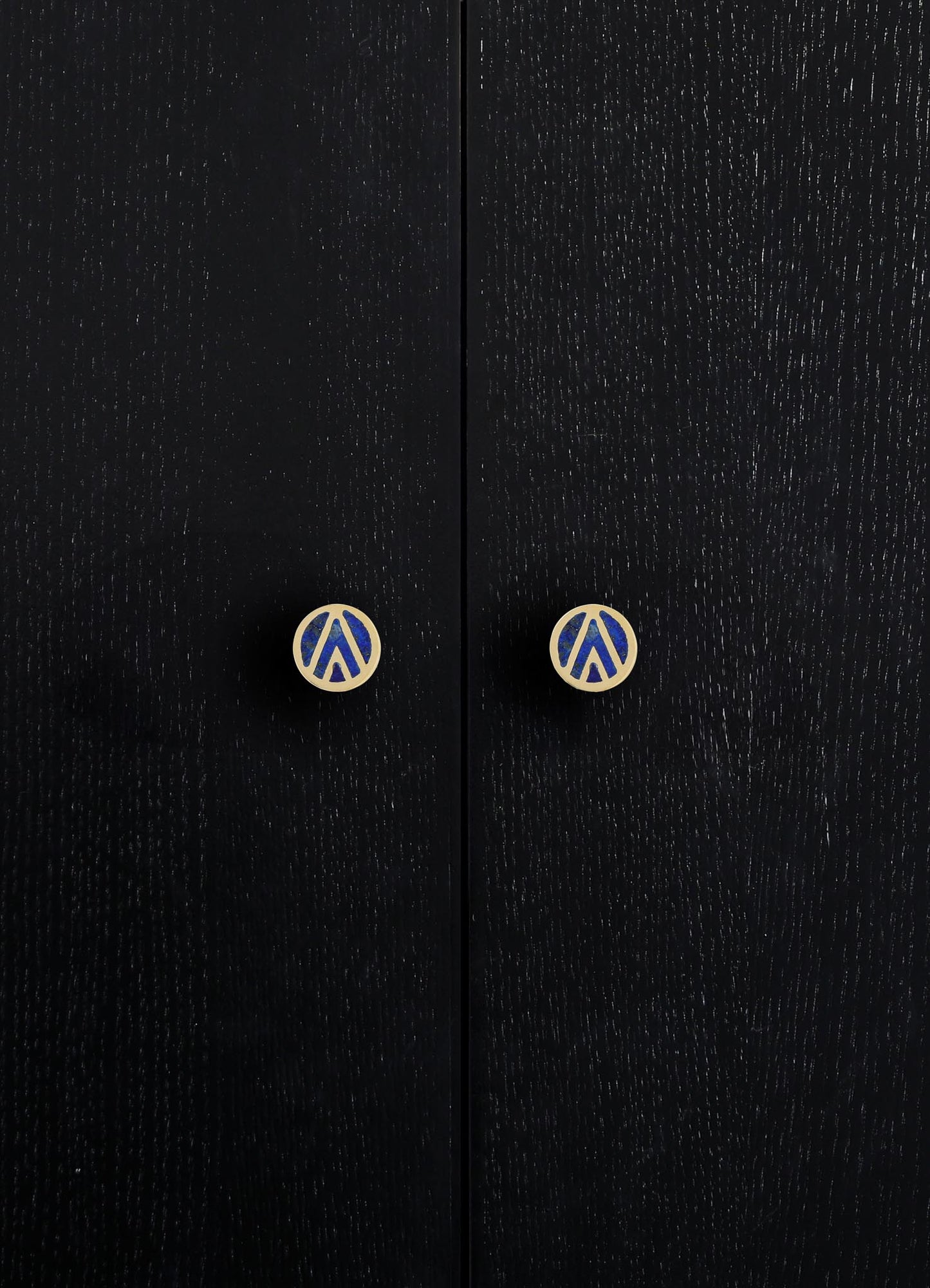 Black wooden cabinet doors with a textured finish and round knobs featuring a blue and beige graphic pattern.