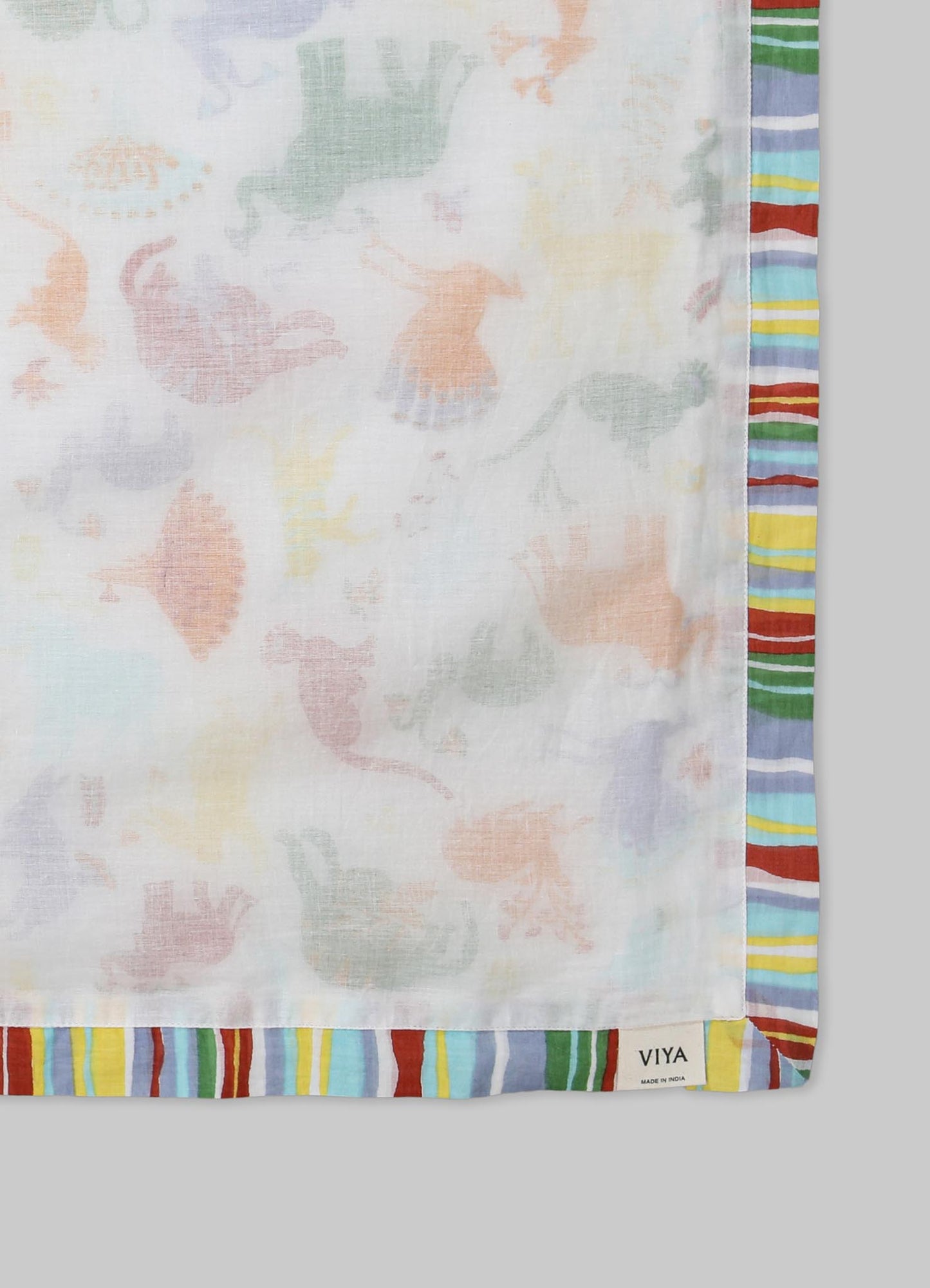 Lightweight cotton scarf with a pastel floral motif in soft shades, bordered by a multi-colored striped pattern in red, blue, green, yellow, and purple. The fabric appears semi-transparent with a casual, contemporary style.