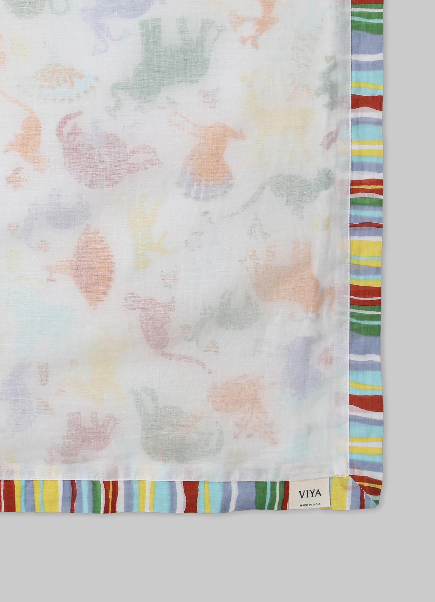 Lightweight cotton scarf with a pastel floral motif in soft shades, bordered by a multi-colored striped pattern in red, blue, green, yellow, and purple. The fabric appears semi-transparent with a casual, contemporary style.