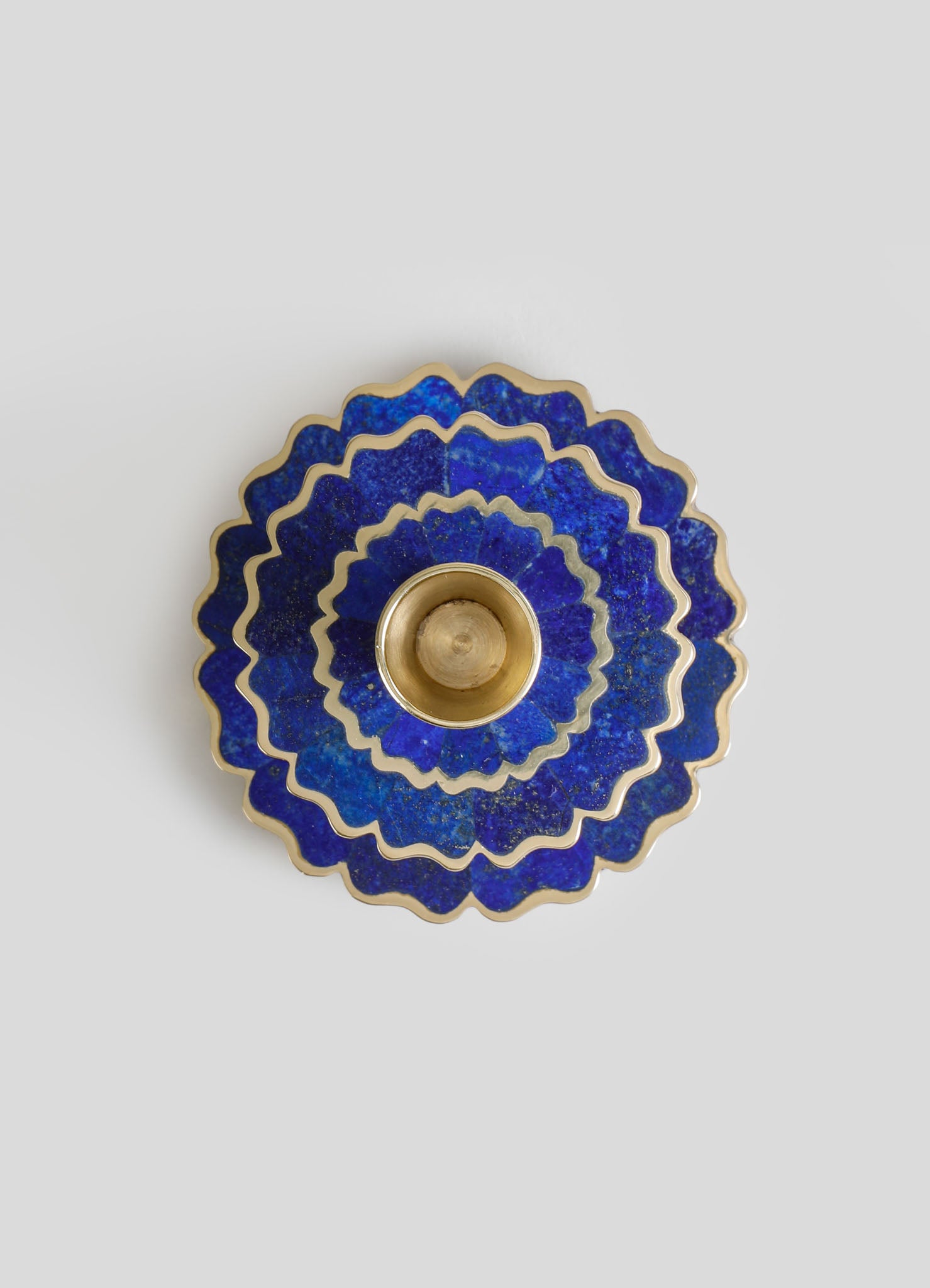 A decorative blue glass bowl with scalloped edges and gold trim, featuring a floral motif and a glossy finish. The bowl has a central gold-colored lining, emphasizing its luxurious and handcrafted style.