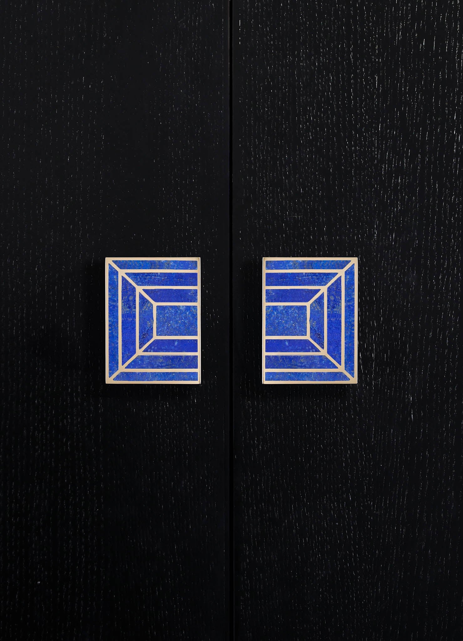 Two dark wood cabinet doors with textured wood grain, each featuring a blue and white geometric-patterned handle with rectangular and linear motifs.
