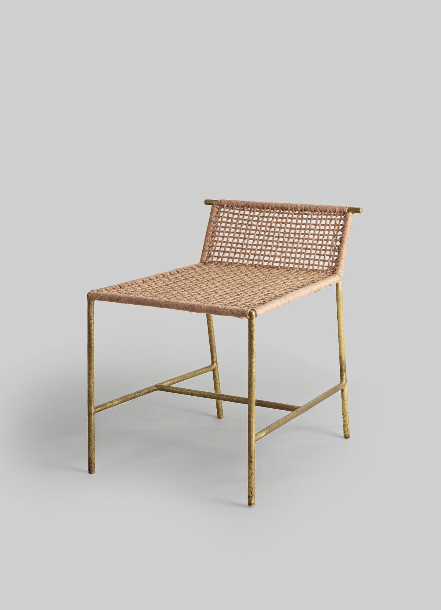A side chair with a gold-toned metal frame and a woven rattan seat and backrest, combining rustic and contemporary styles.