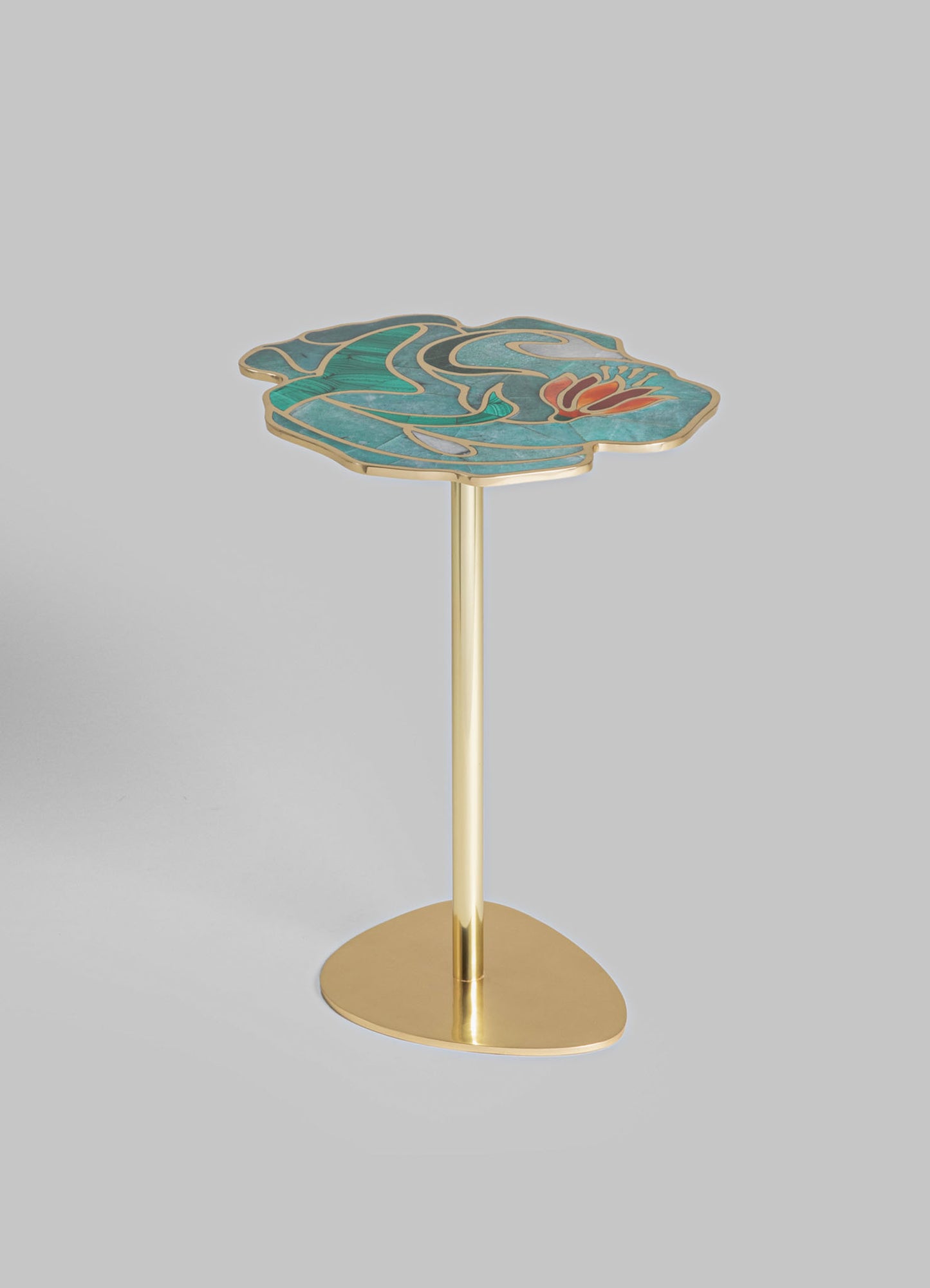 A side table with a floral-shaped top featuring colorful inlaid patterns in shades of teal, orange, and cream, set on a slender gold metal pedestal with a rounded gold base.