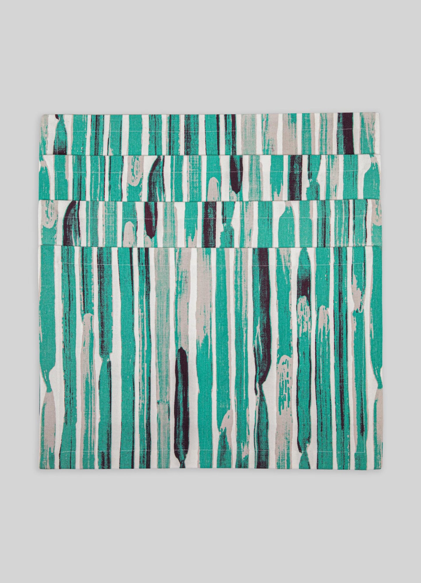 Handwoven textile or placemat with an abstract pattern of vertical brushstrokes in teal, black, and beige tones, made from natural fibers. The design has a contemporary, artistic style with a textured appearance.