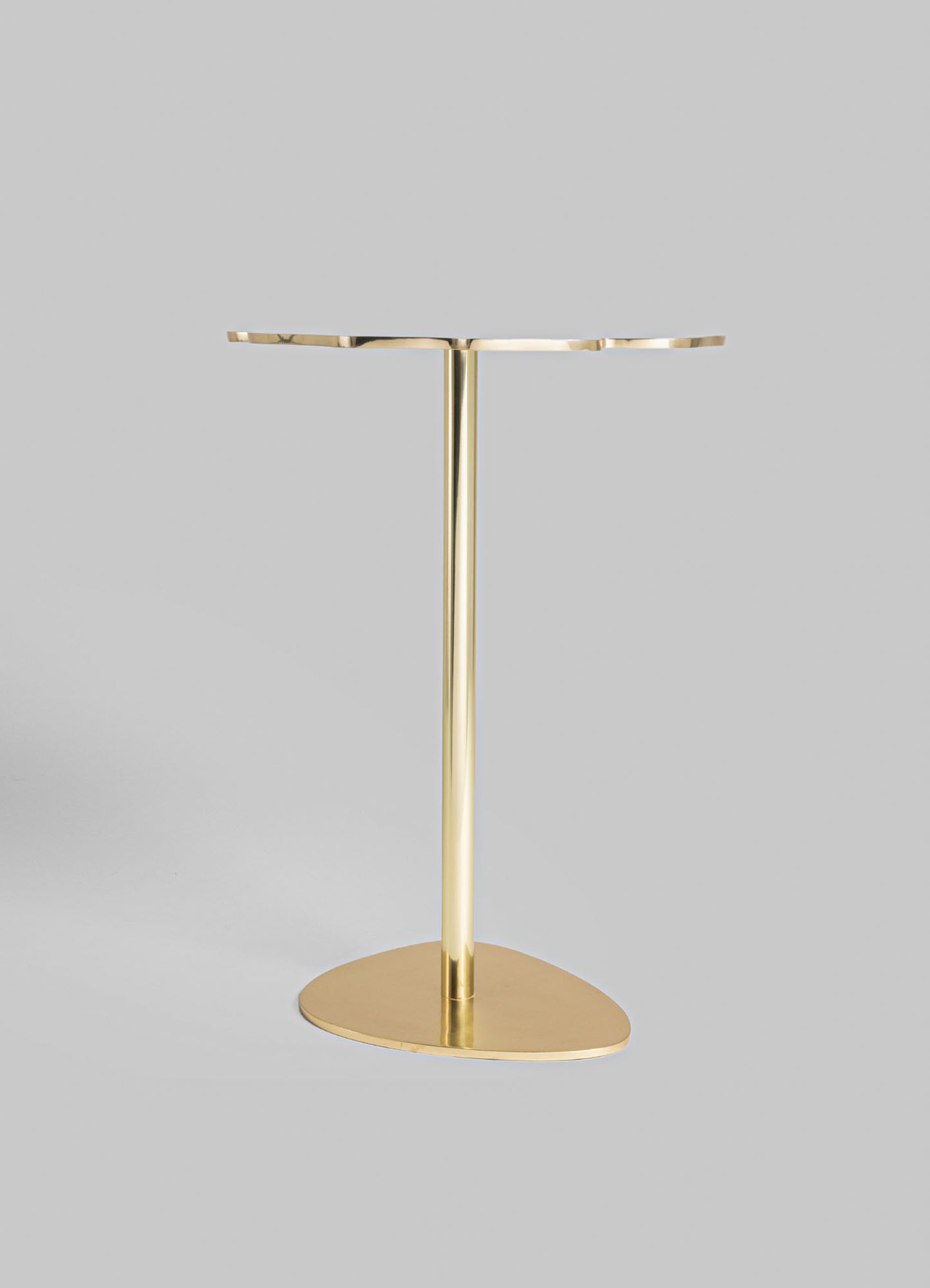 A gold-colored metal side table with an oval-shaped top and a round base, featuring a sleek, minimalist design. The table has a vertical support column connecting the top and base, suitable for contemporary interior spaces.