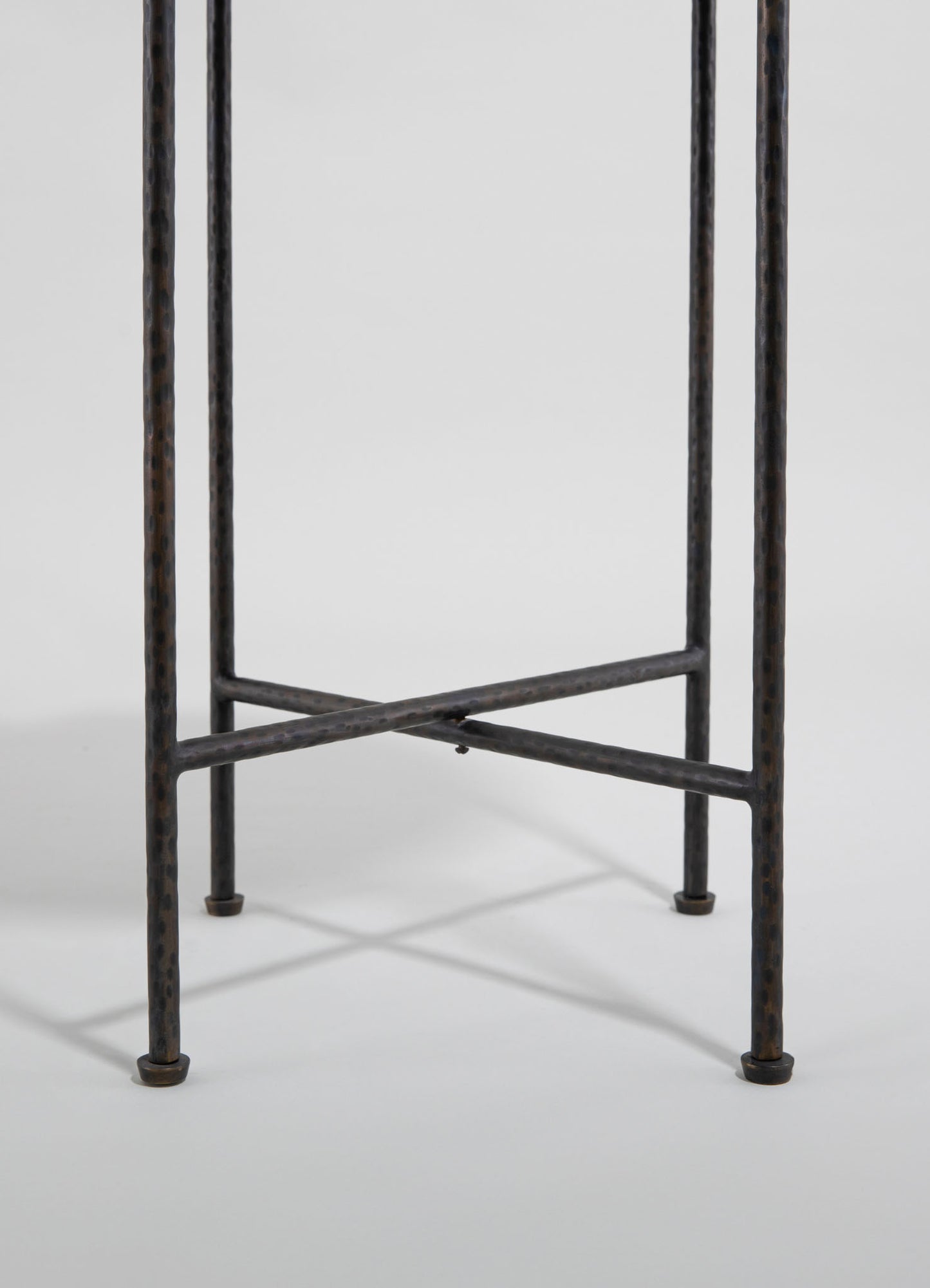 A black metal plant stand with a hammered texture, featuring four vertical legs connected by crossbars, set against a plain background.