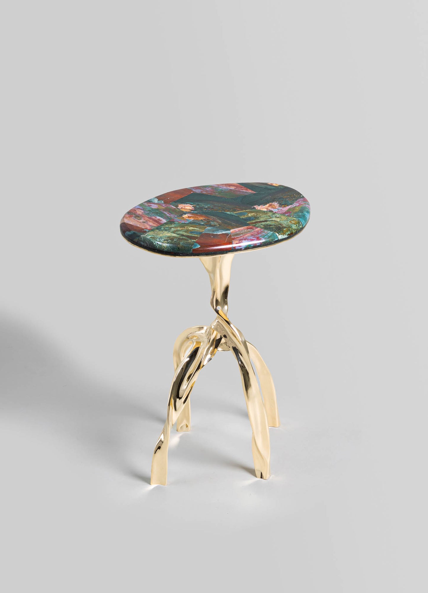 A small side table with a multicolored marble top featuring swirling patterns and a polished finish, supported by an artistic, gold-toned metal base with sculptural, organic lines.