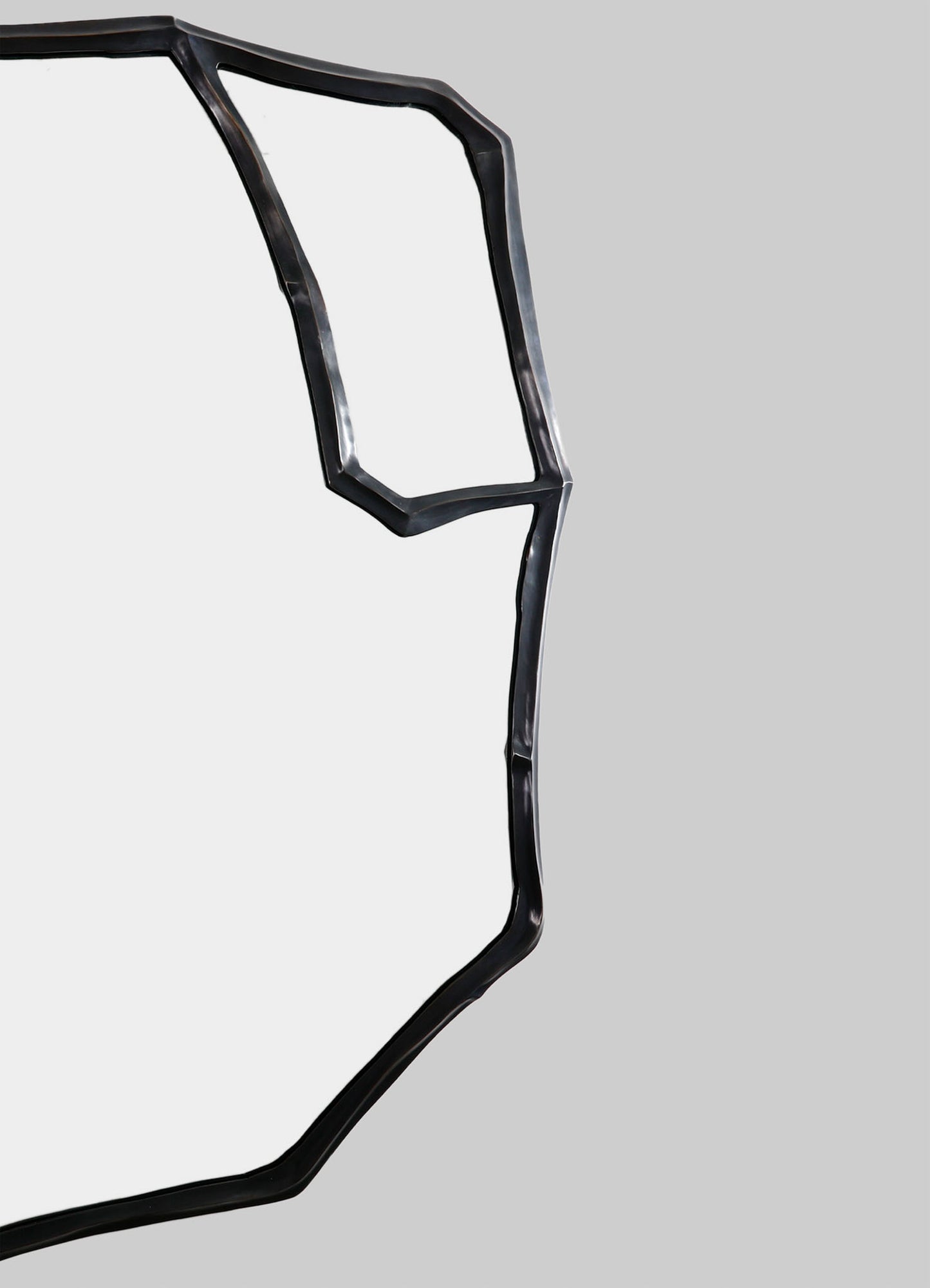 Abstract black metal sculpture with irregular geometric lines and a matte finish, set against a neutral background.