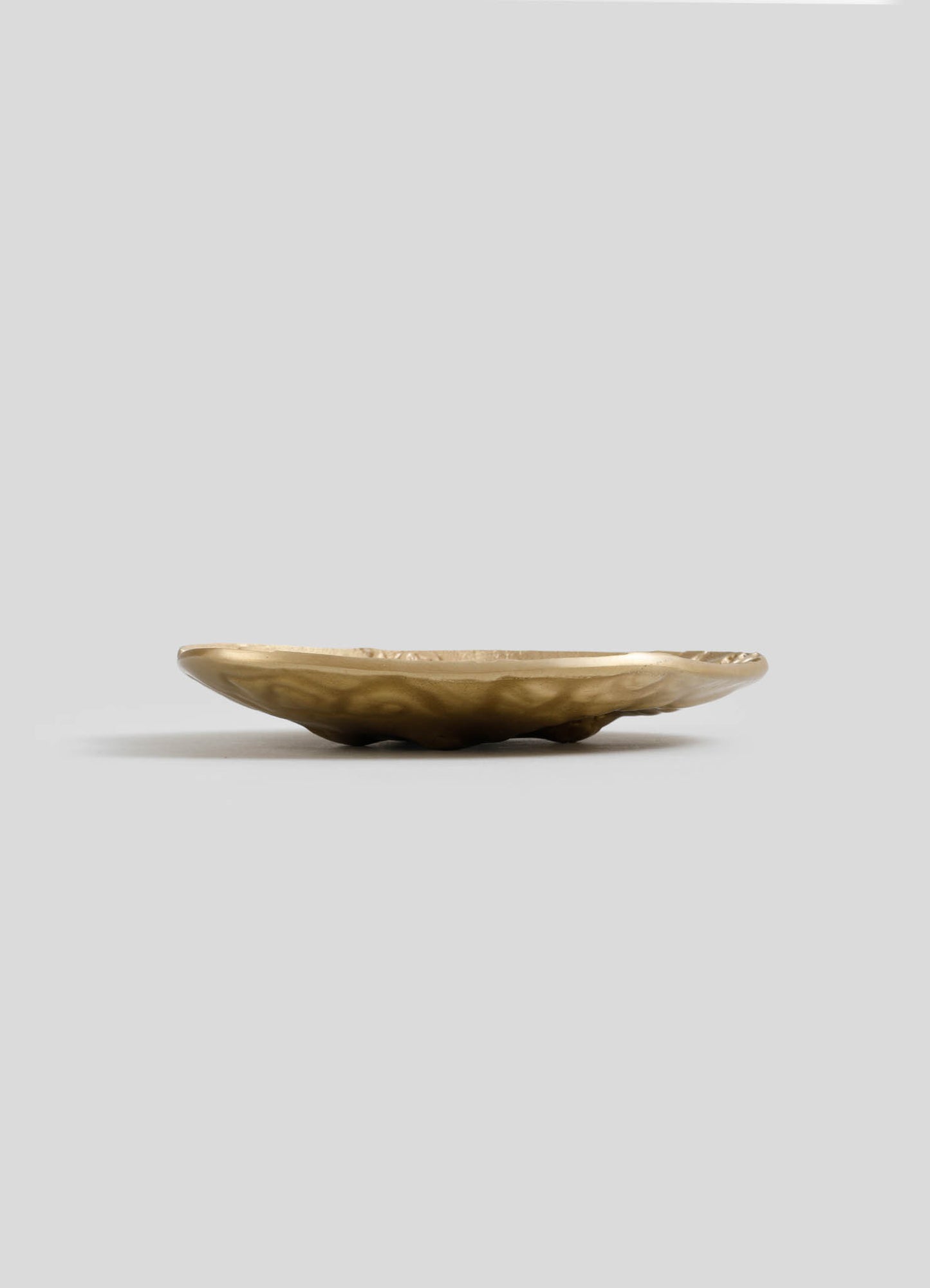 A shallow bowl made of polished, natural stone with a smooth, rounded shape and earth-toned coloration.