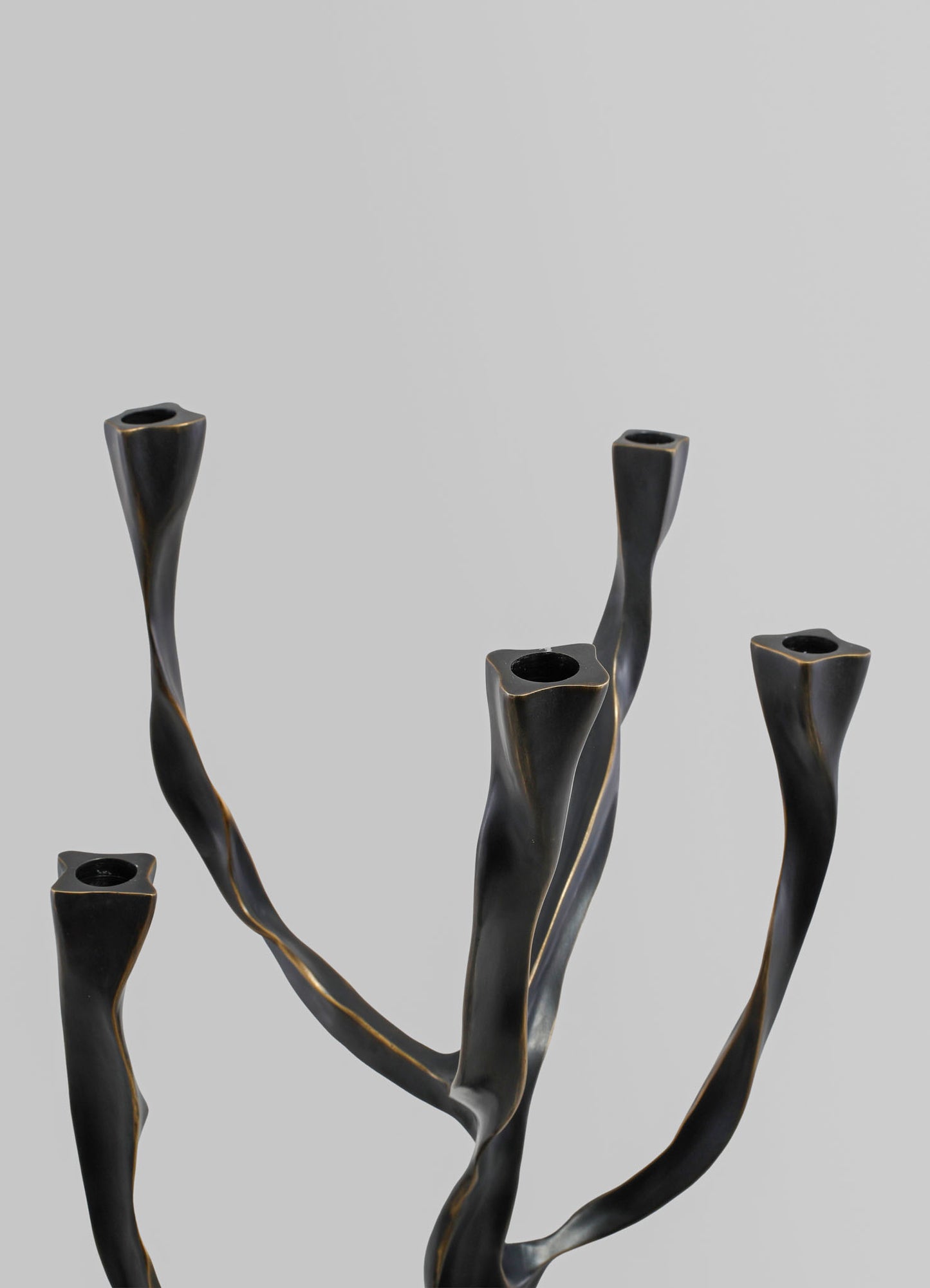 Metallic black candle holder with twisted, organic-shaped branches and a glossy finish.