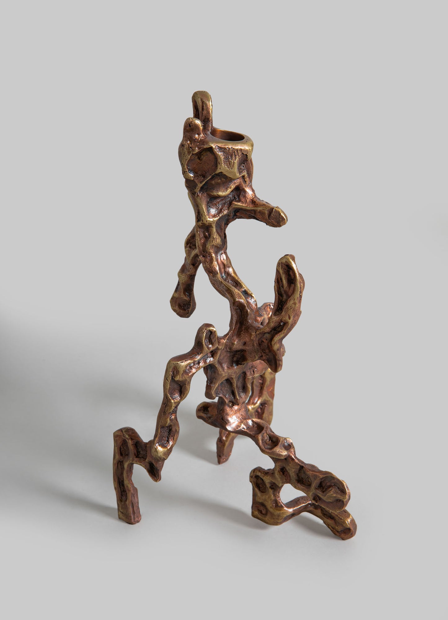 Copper sculpture with an abstract, organic form featuring textured, irregular surfaces and a polished finish. The sculpture has a natural, artistic style with flowing, intertwined shapes against a plain background.