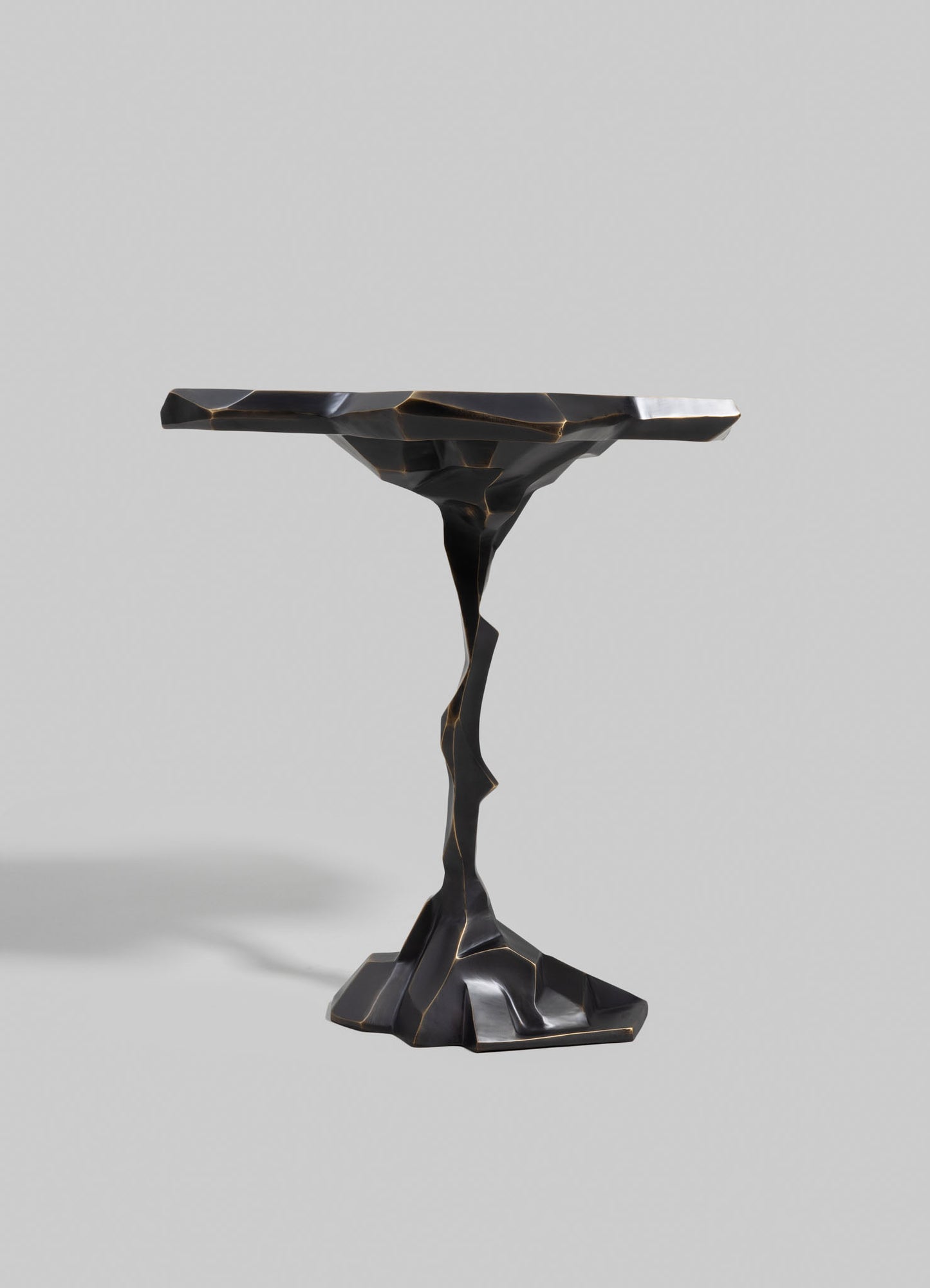 A sculptural side table with a black, glossy finish and irregular, organic shaping, featuring a jagged, textured surface on the tabletop and a contrasting smooth, sculpted base. The design emphasizes contemporary aesthetics with an artistic, avant-garde style.