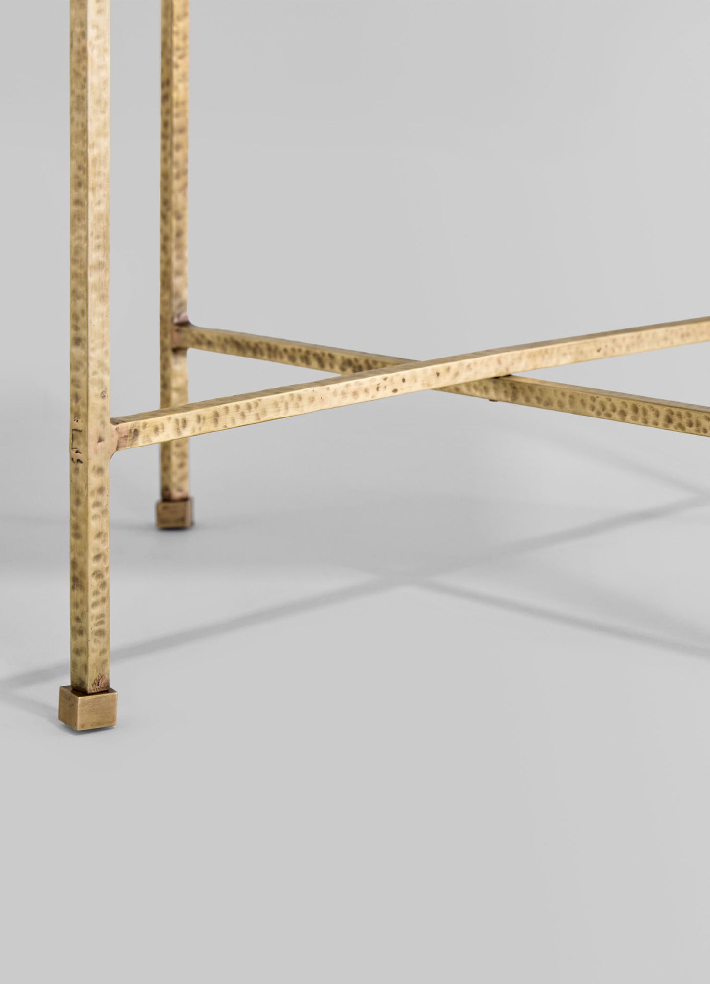 Hammered brass table with a rectangular top and square legs, featuring a textured, dimpled finish and a warm metallic gold tone.