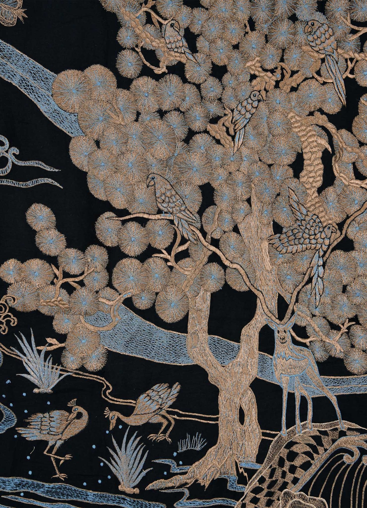 The Viya Dreamscape Black & Gold Embroidered Bedcover features birds on branches, a deer under a tree, and ducks by water, all rendered in beige and light blue on dark fabric—showcasing symbolic motifs often seen in embroidered textiles.