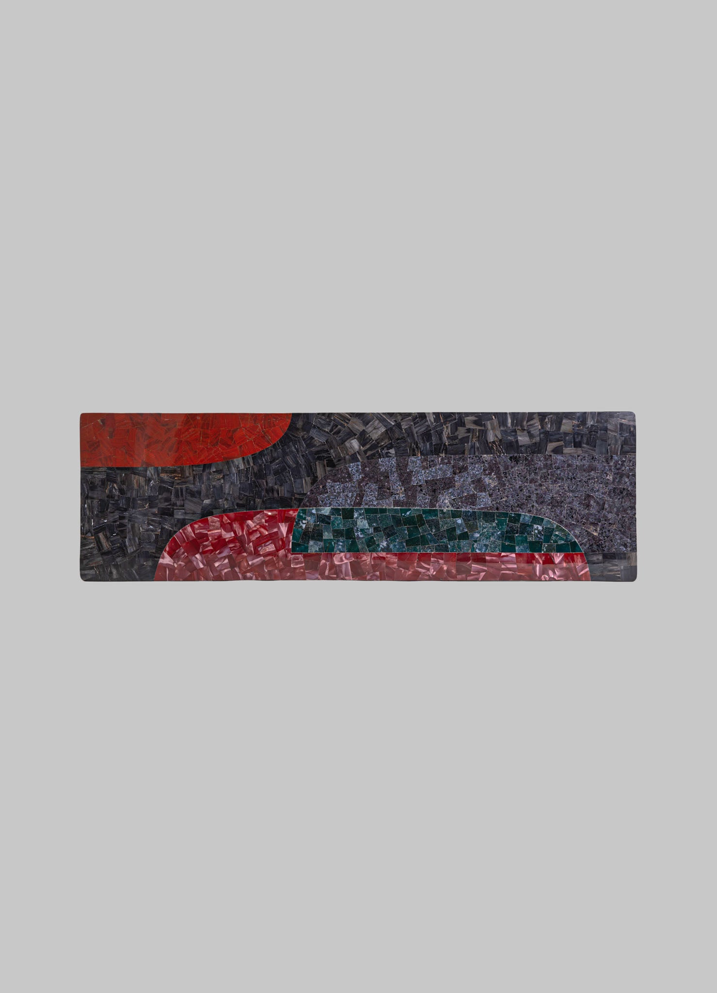 Long rectangular mosaic table with abstract geometric motifs in red, green, blue, black, and pink tones, featuring a textured glass and stone surface.