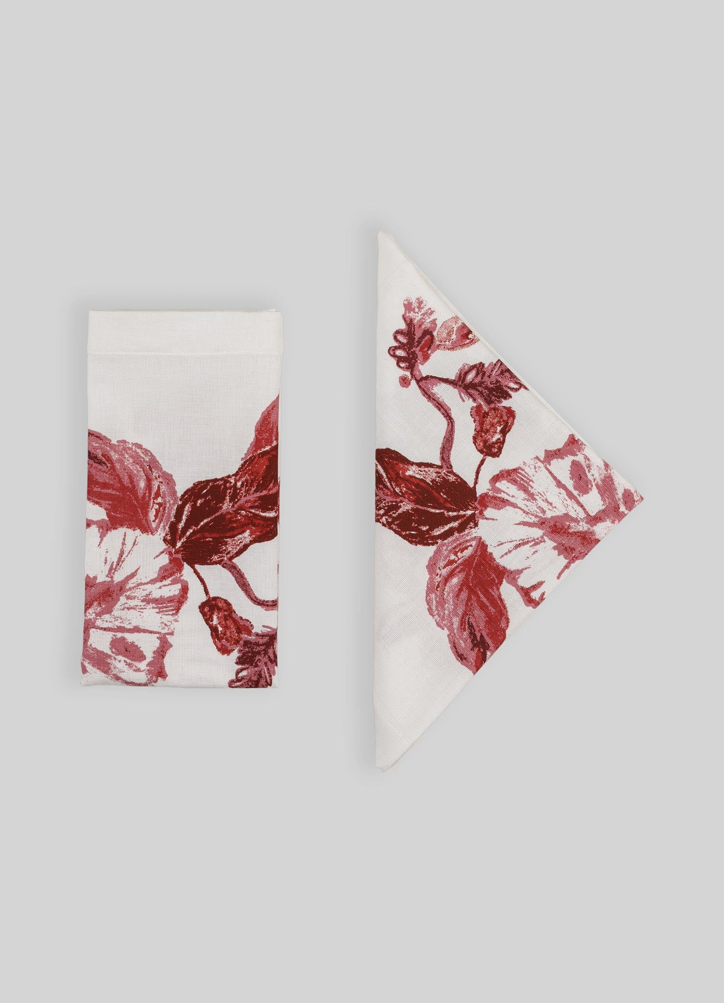 Cotton napkin and cloth with a red floral pattern on a white background, featuring large, stylized flowers and leaves in a bold, painterly style.