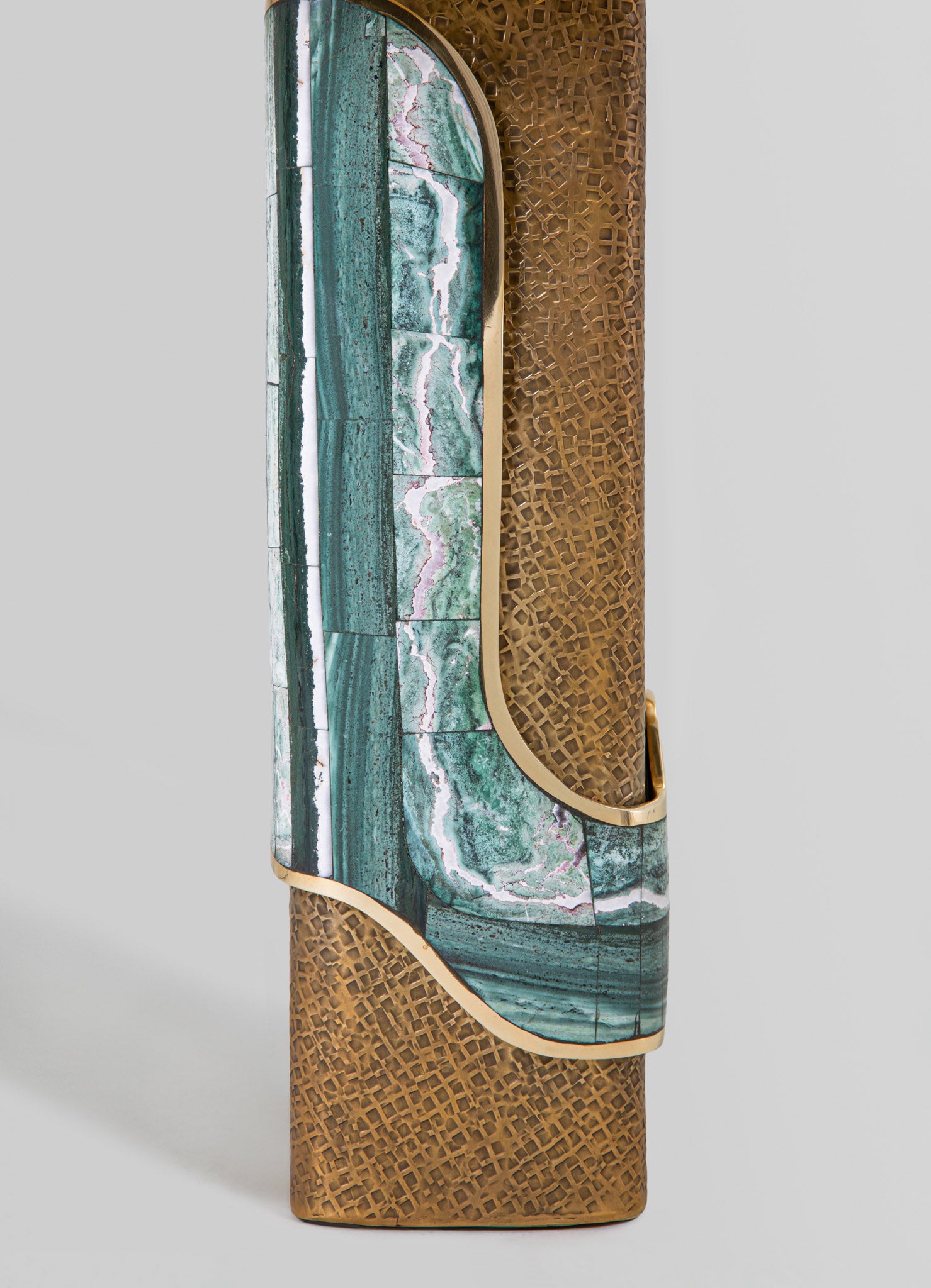 A tall decorative vase featuring a combination of teal and green marble patterns with gold accents. The design includes geometric and organic motifs, blending contemporary style with luxurious materials.