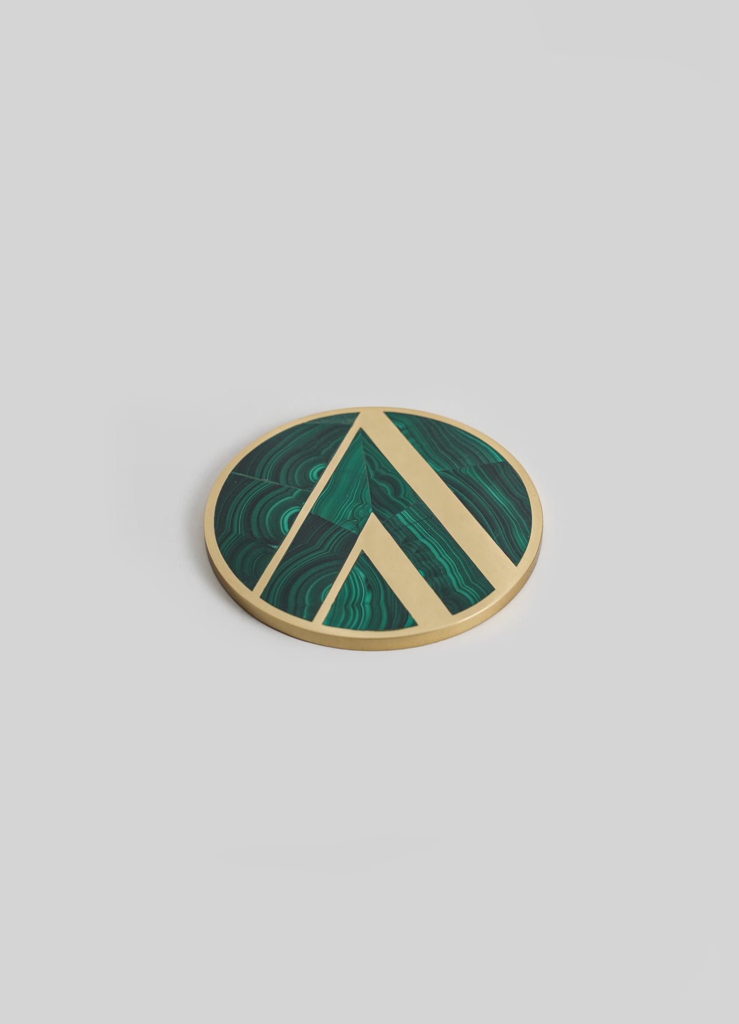 Round decorative tray with a marbled green malachite design and a gold-colored metal rim, featuring geometric line accents, set against a plain background.