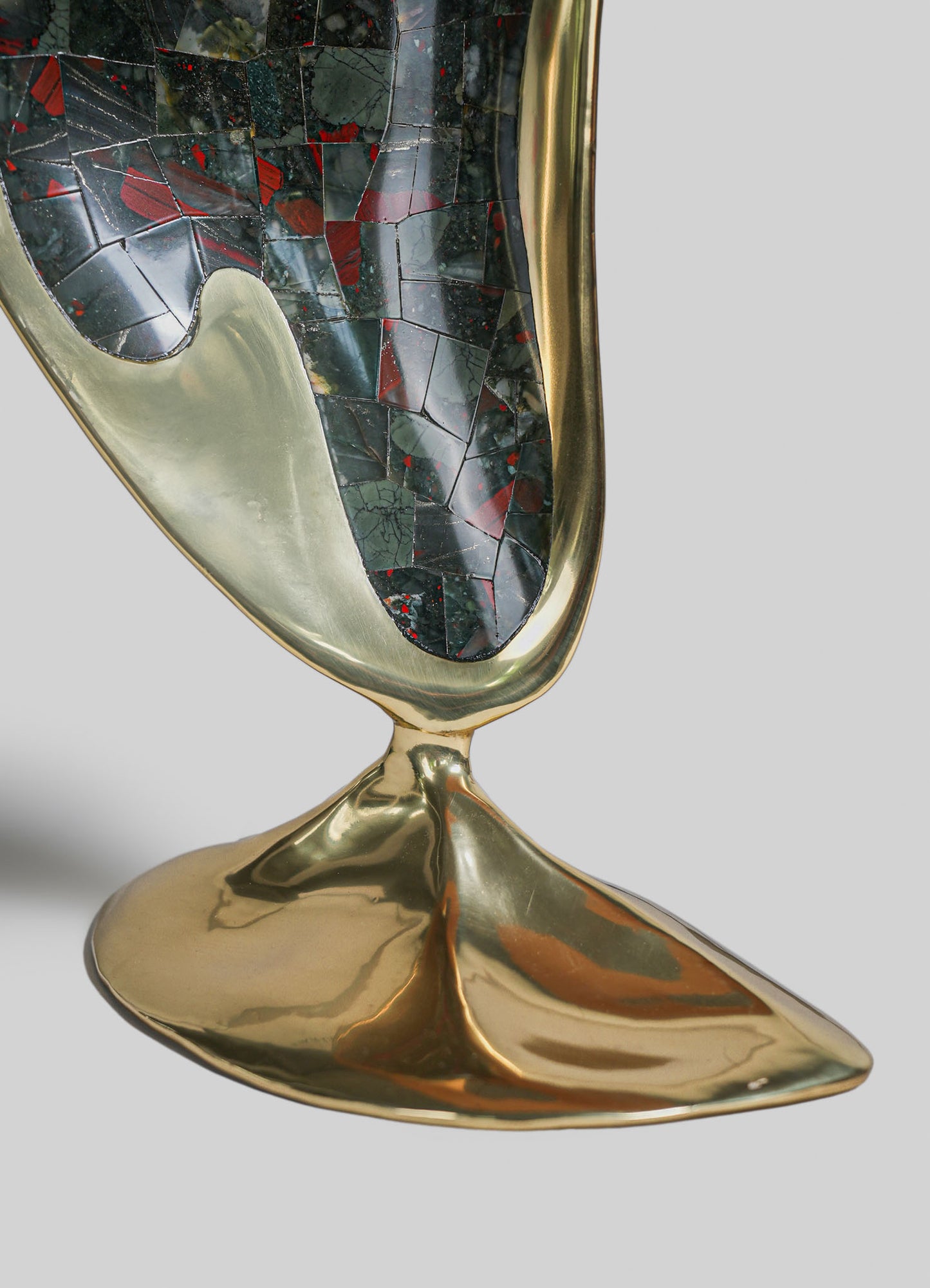 A decorative tray with a gold-colored metal frame and base, featuring a mosaic pattern of red, black, and green tiles with irregular shapes and a glossy finish.