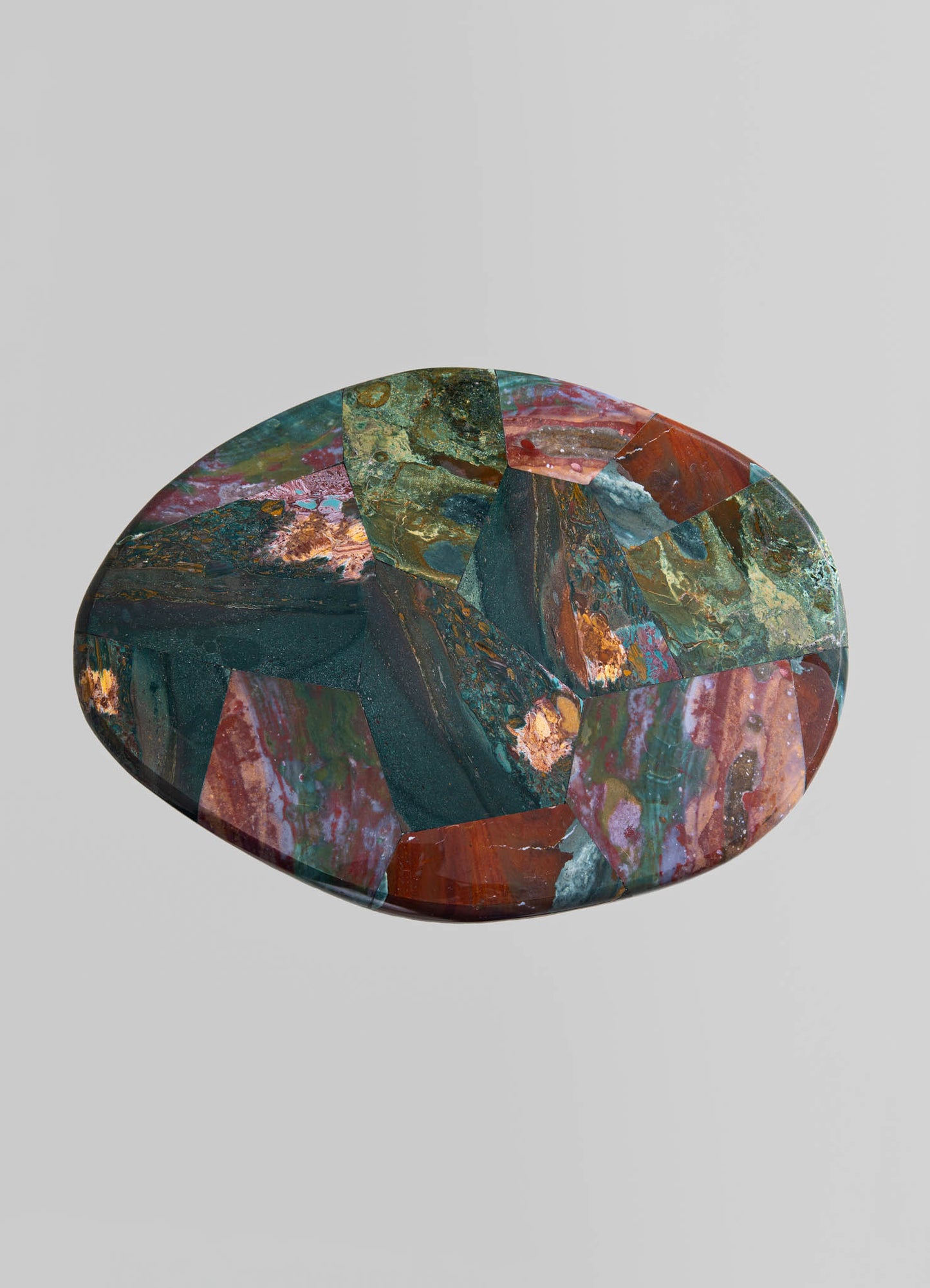 Colorful stone trivet with an abstract, irregular pattern in shades of green, red, pink, and blue, featuring a smooth, polished surface.