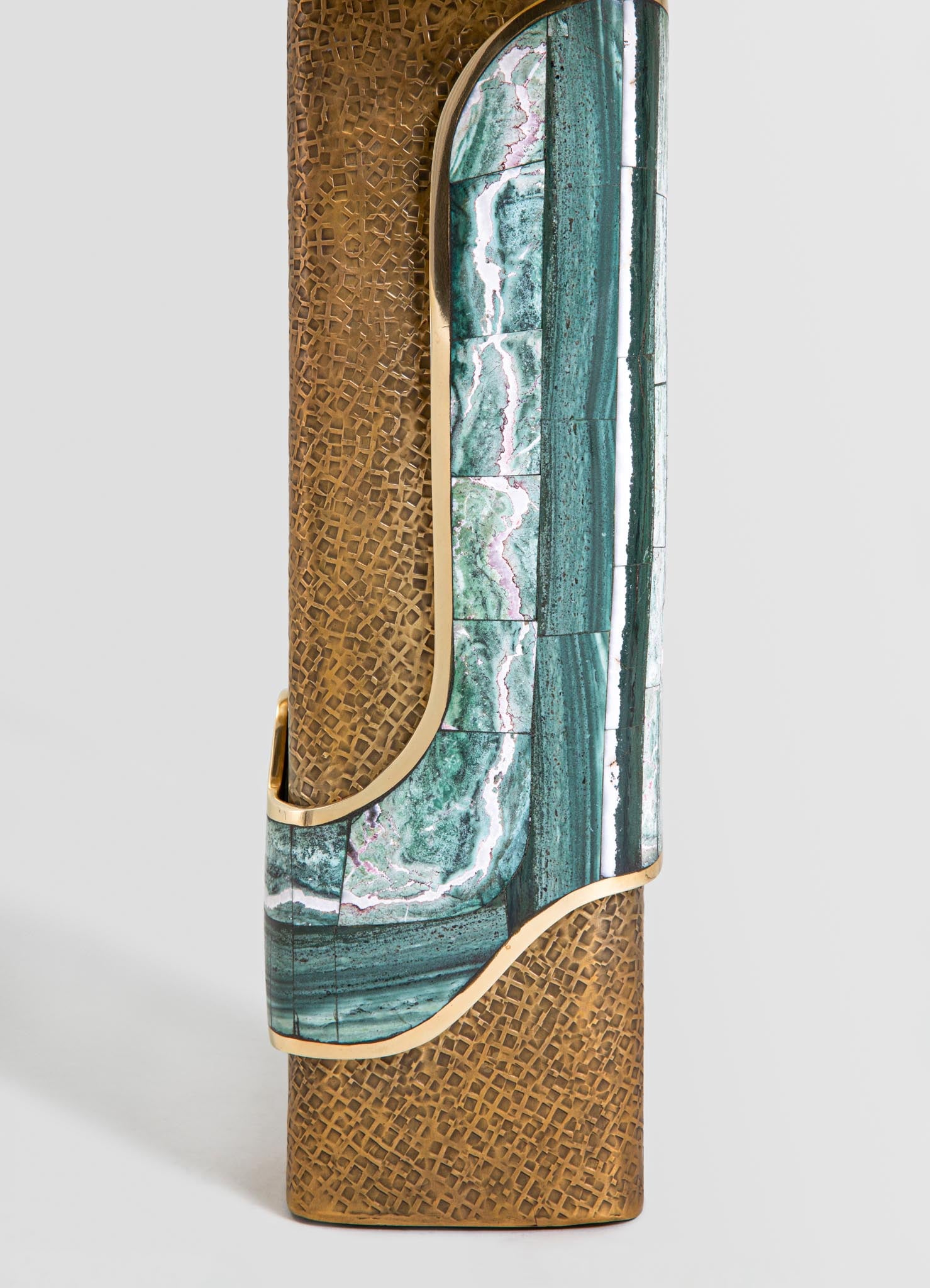 A decorative vase featuring a combination of materials, including a marbled green and white stone surface with pink veining and a textured, lattice-patterned bronze or brass element. The design is contemporary with a sculptural shape and contrasting finishes.