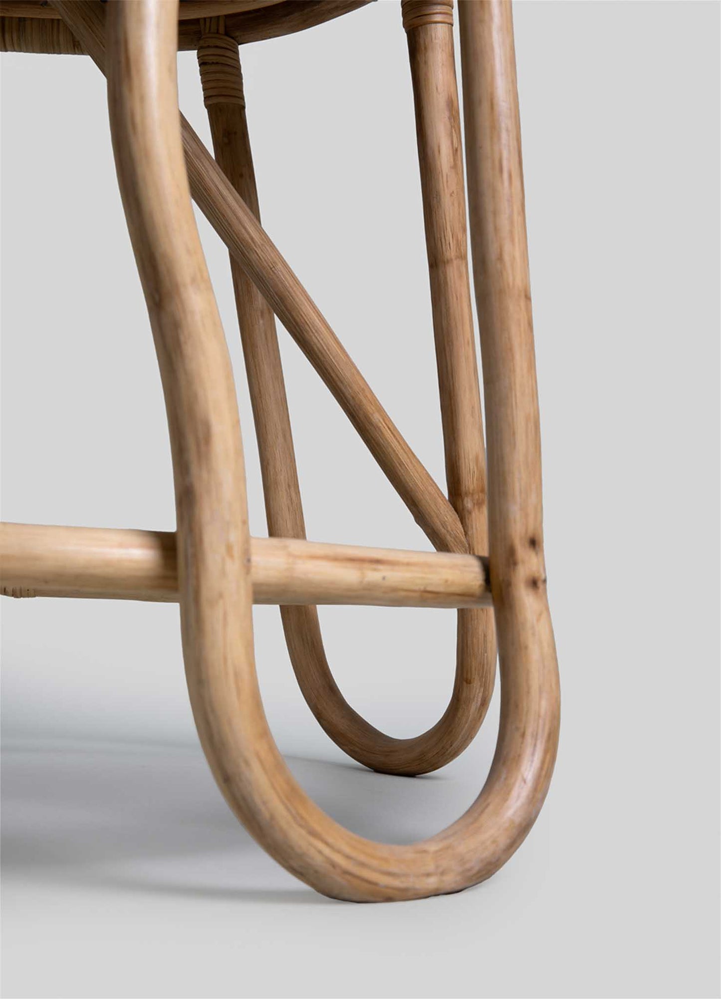 Wooden furniture leg with a natural finish, featuring curved and straight cylindrical forms and a crossbar support, in a minimalist style.