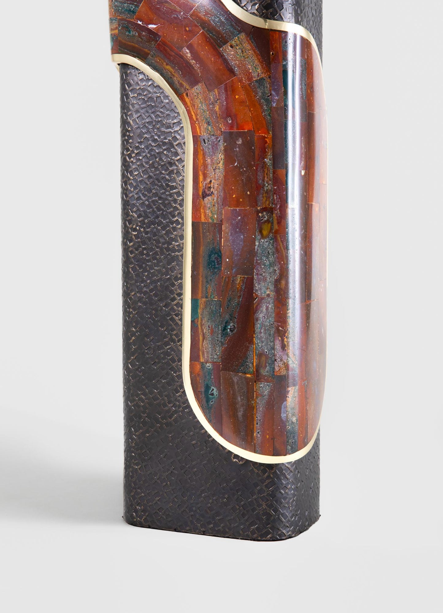 A floor lamp with a cylindrical body constructed from textured brass or metal with a woven pattern, combined with an inlaid panel of irregularly shaped onyx or marble in warm reddish-brown tones, bordered by gold trim.