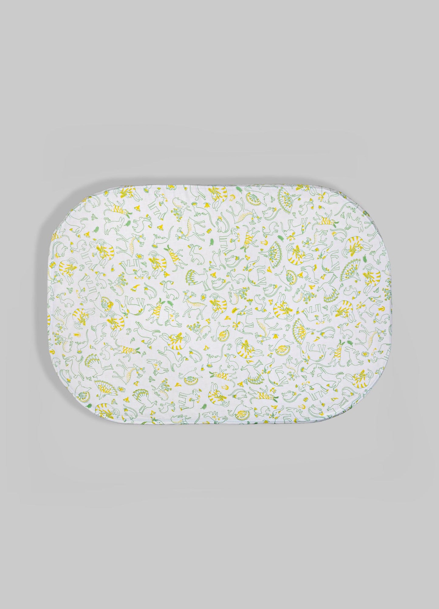 An oval-shaped baby changing pad with a fabric cover featuring a playful animal print in yellow and green on a white background. The cover appears to be made of soft cotton material.