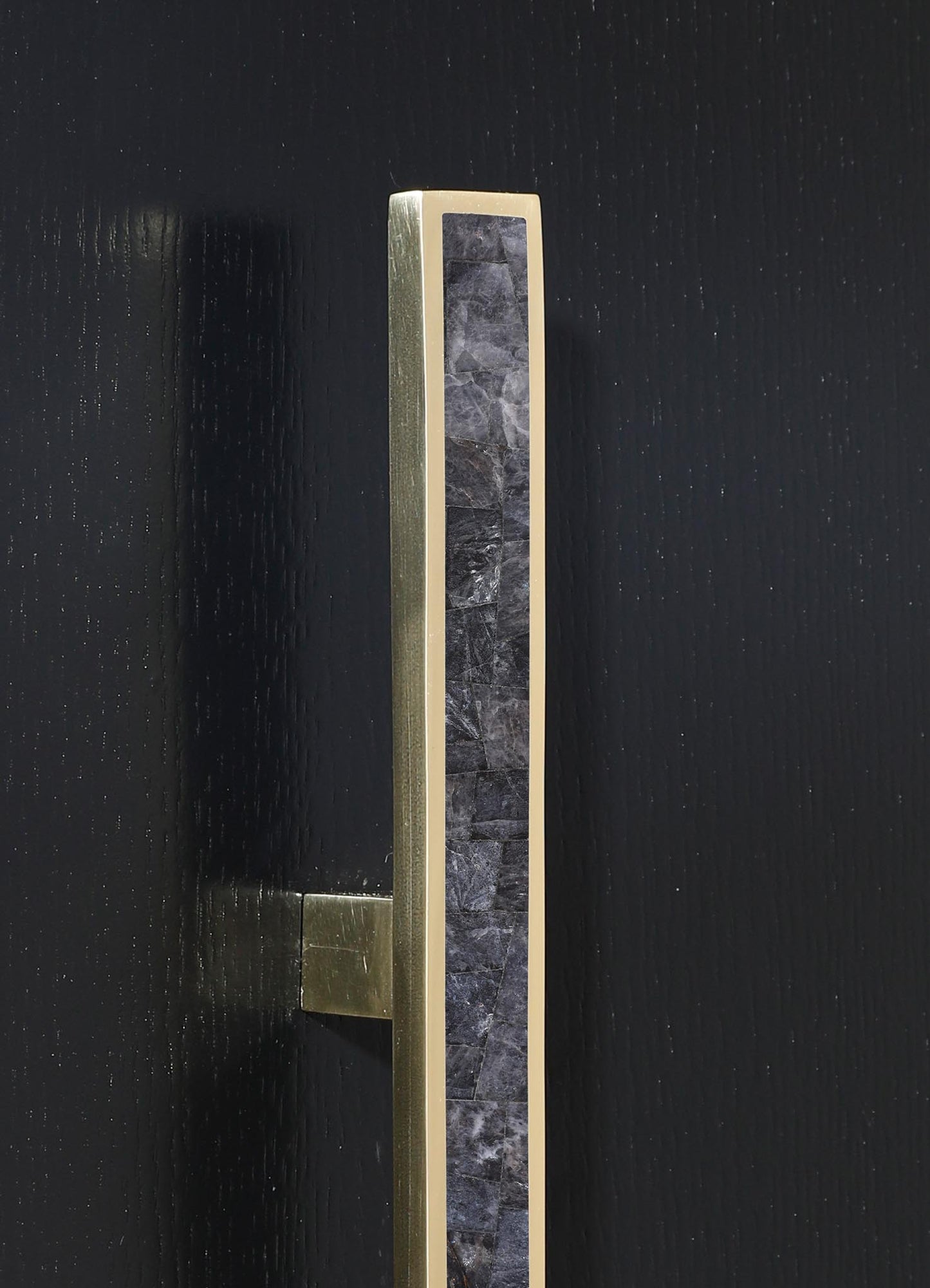 A modern door handle featuring a sleek gold-colored metal frame with a central vertical strip of black marble veins on a matte black background. The design combines contemporary elegance with natural stone accents, emphasizing minimalism and luxury.