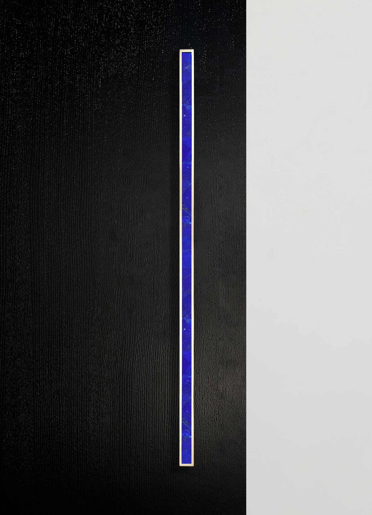 A vertical strip of blue marble with gold trim, set against a split black and white textured background.