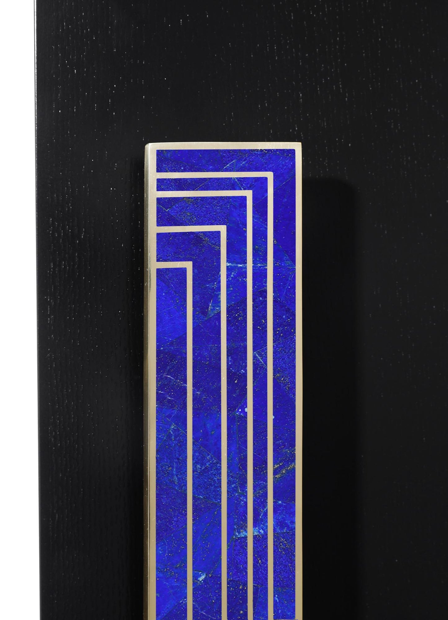 A decorative tile with a geometric pattern in bold cobalt blue and metallic silver accents, set against a black textured surface. The tile features a modern style with clean lines and contrasting colors.