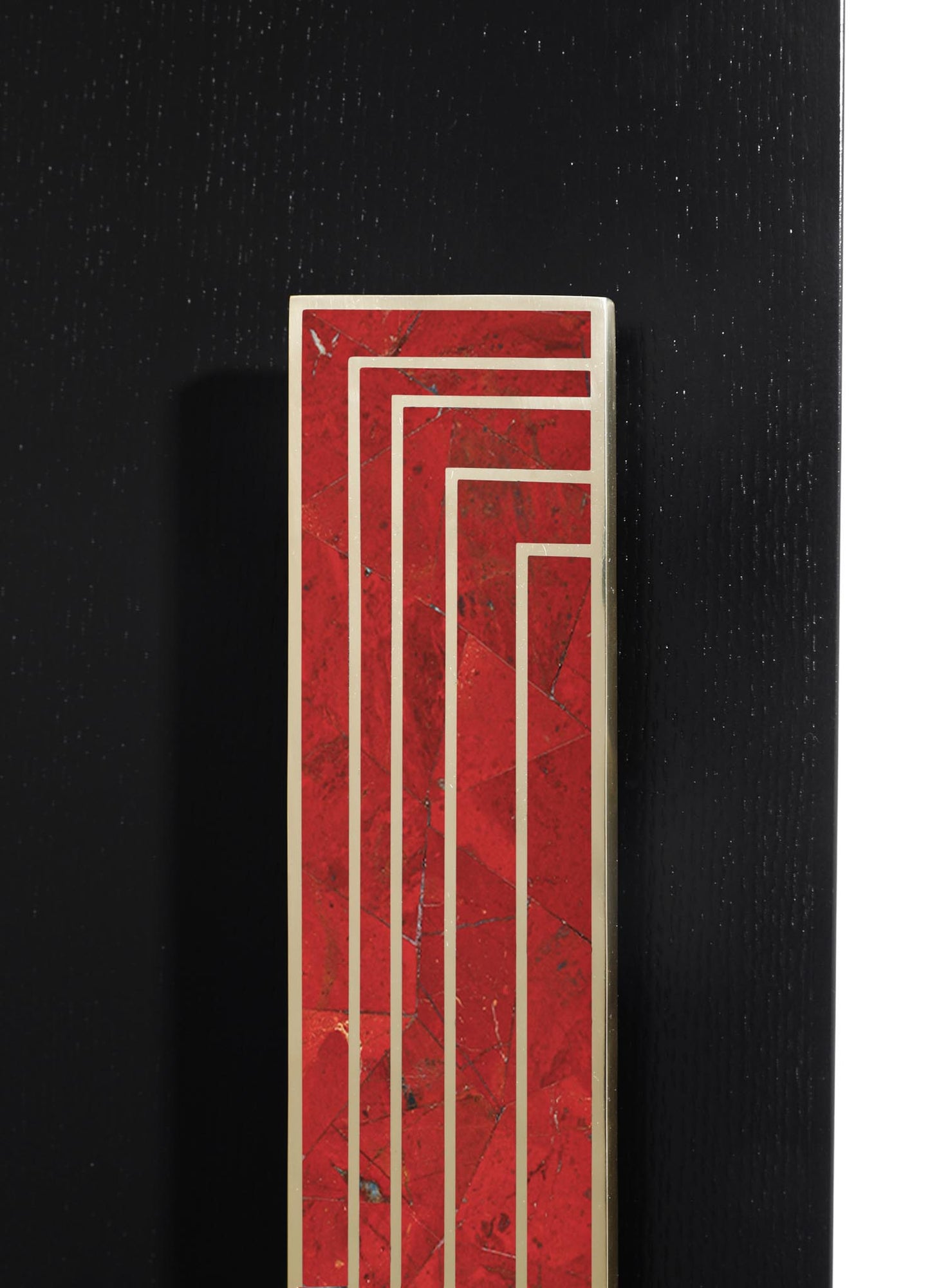 A rectangular table lamp with a red marble body featuring subtle veining, accented by a metallic frame and geometric pattern, set against a black textured background.