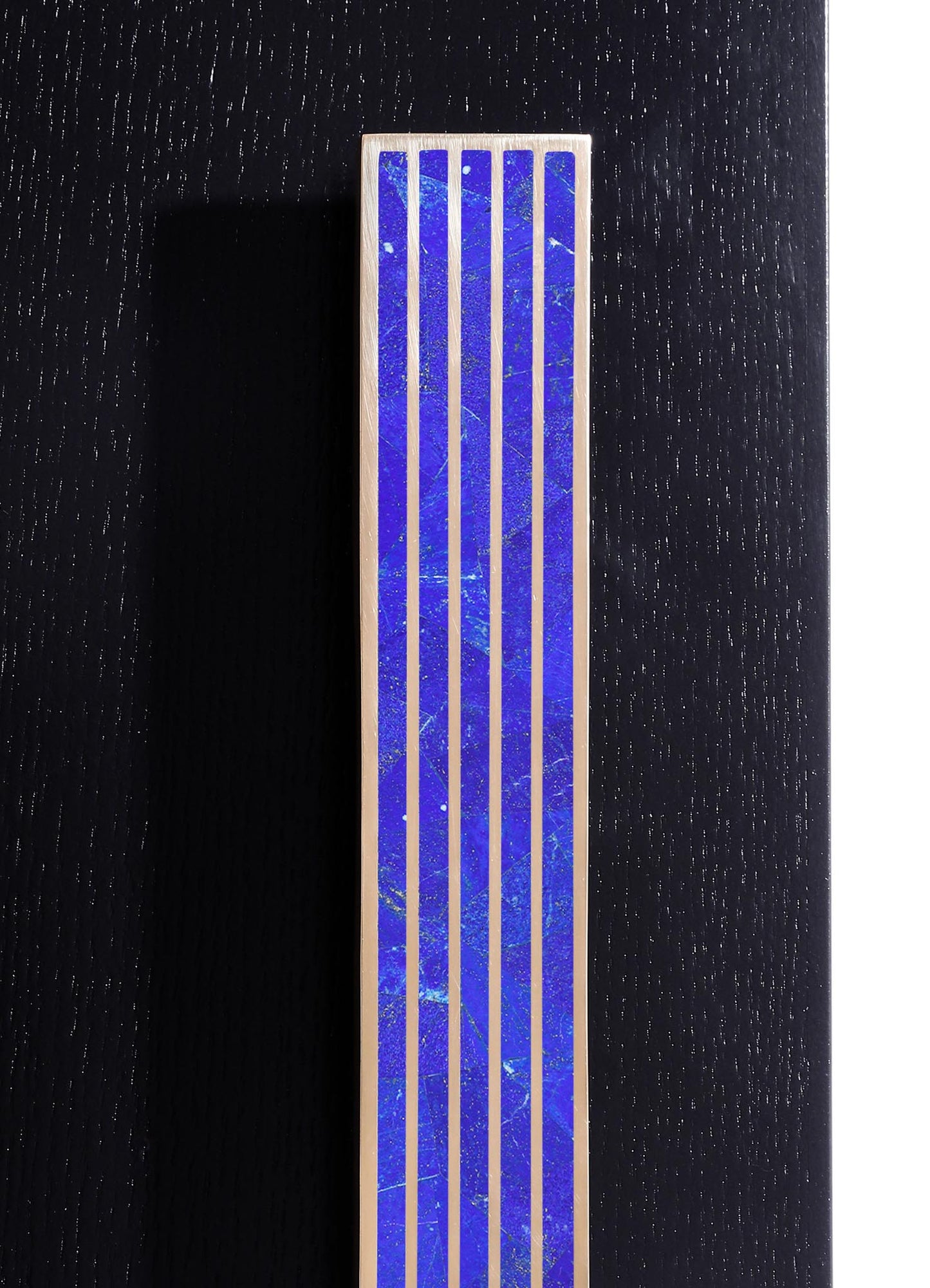 A close-up of a decorative tile panel featuring deep blue, marble-effect ceramic tiles with white veining, framed by thin white grout lines. The tiles are arranged in a vertical pattern, contributing to a modern and elegant design style.