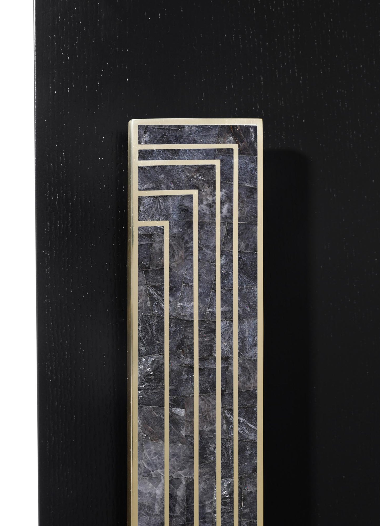 A rectangular decorative object featuring a black marble surface with gray veining, framed by gold-tone metal lines arranged in a geometric pattern, set against a black textured background.