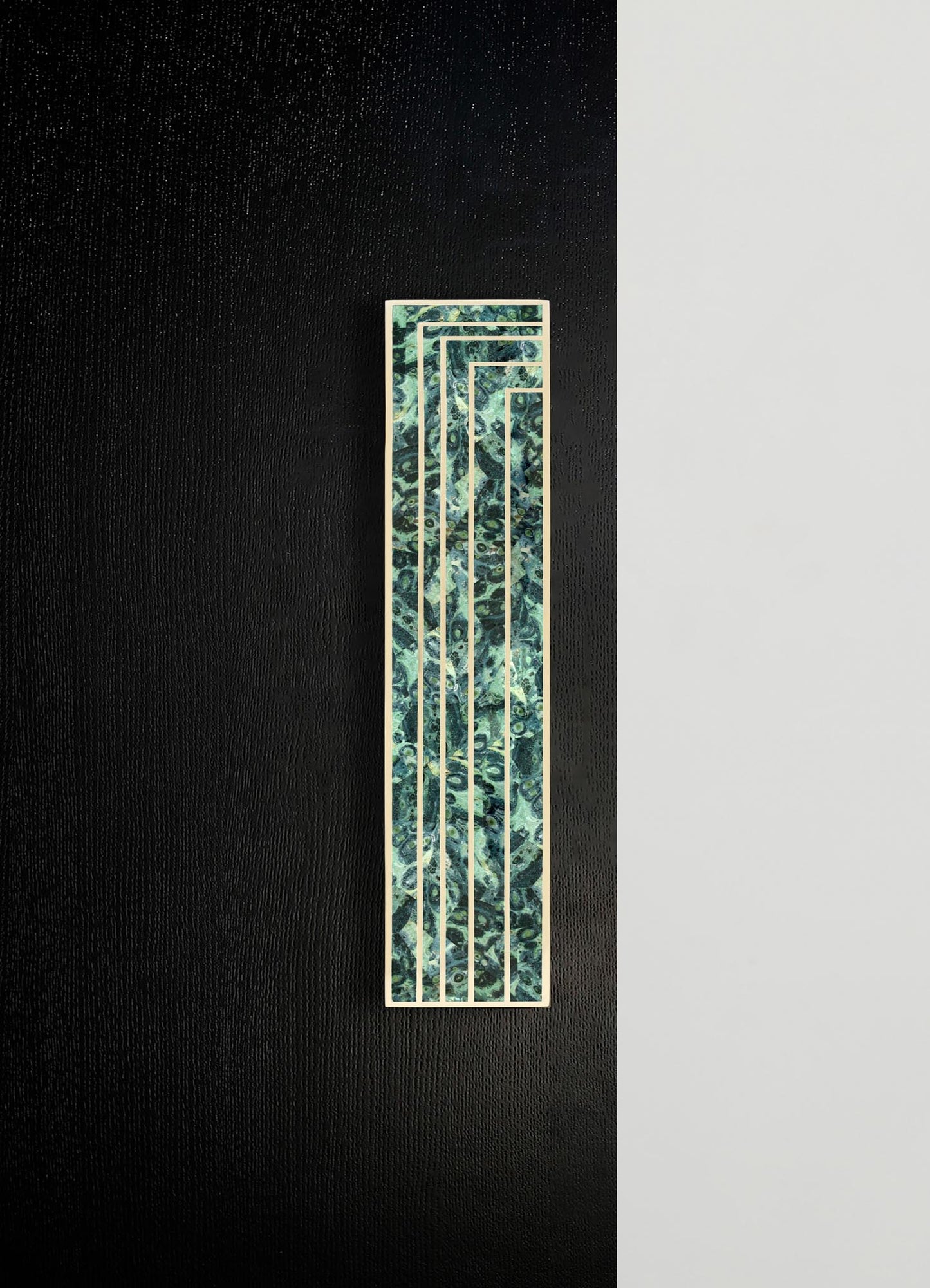 A decorative wall panel featuring a geometric design with multiple rectangular frames and a marbled pattern in shades of green and blue, bordered by light-colored wood.