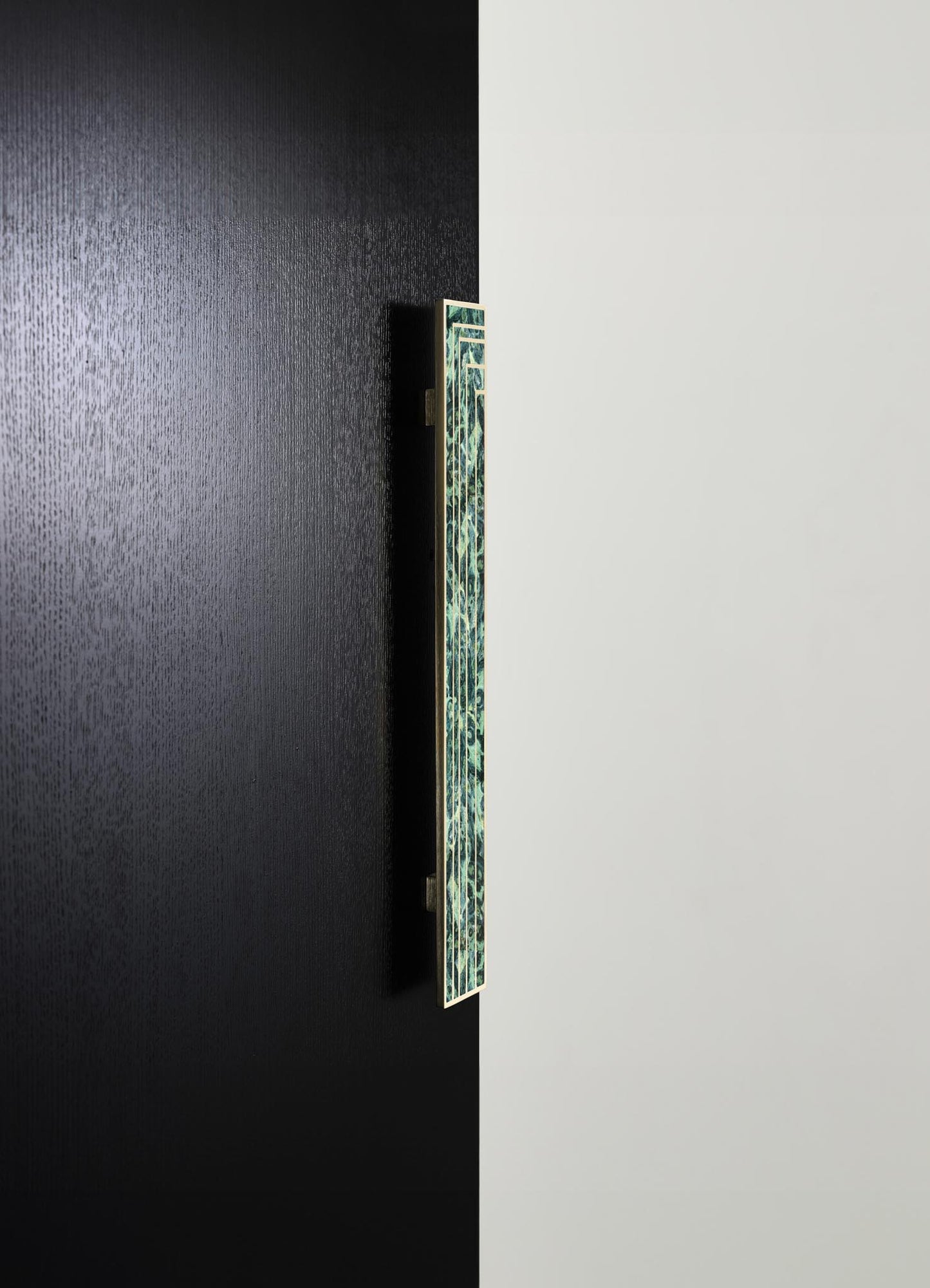 Decorative wall art featuring a vertical rectangular panel with a green and white geometric pattern, mounted on a black textured wall. The panel appears to have a ceramic or tile surface with a modern, minimalist style.