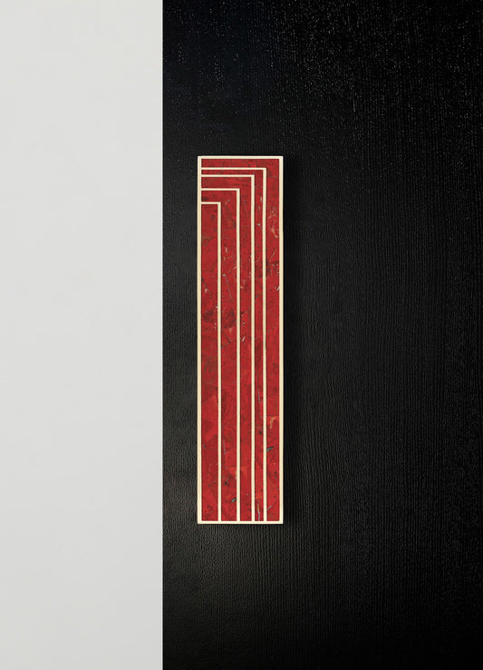 A decorative wall panel featuring red marble with gold-tone geometric lines, mounted on a black textured wall. The design has a modern, minimalist style with bold color contrast and clean lines.