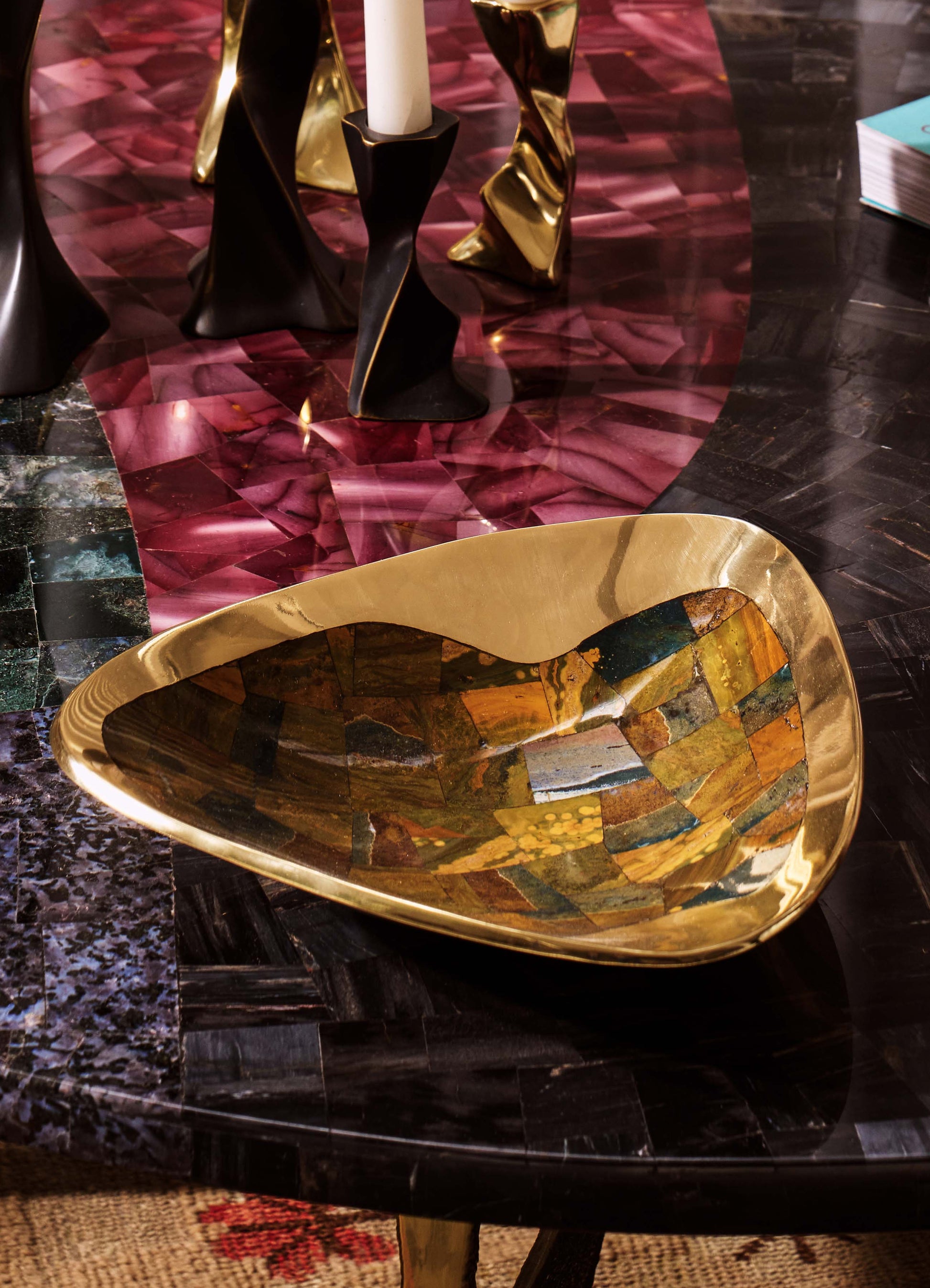 A decorative glass bowl with an irregular shape and a gold metallic rim, featuring a mosaic pattern of multicolored glass tiles on the interior surface.