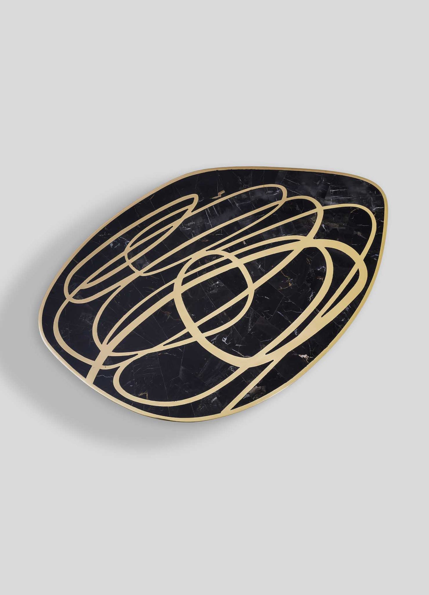 Luxury modern side table with black portoro top and gold abstract swirl design, elegant statement furniture for contemporary living room decor.
