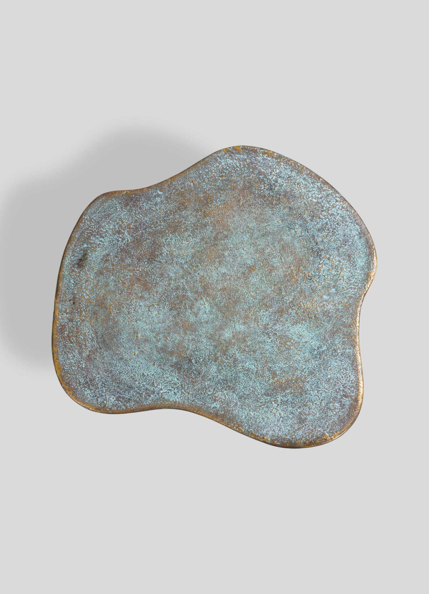 Artistic bronze and turquoise side table with organic irregular shape, luxury accent furniture for modern living room or bedroom decor.